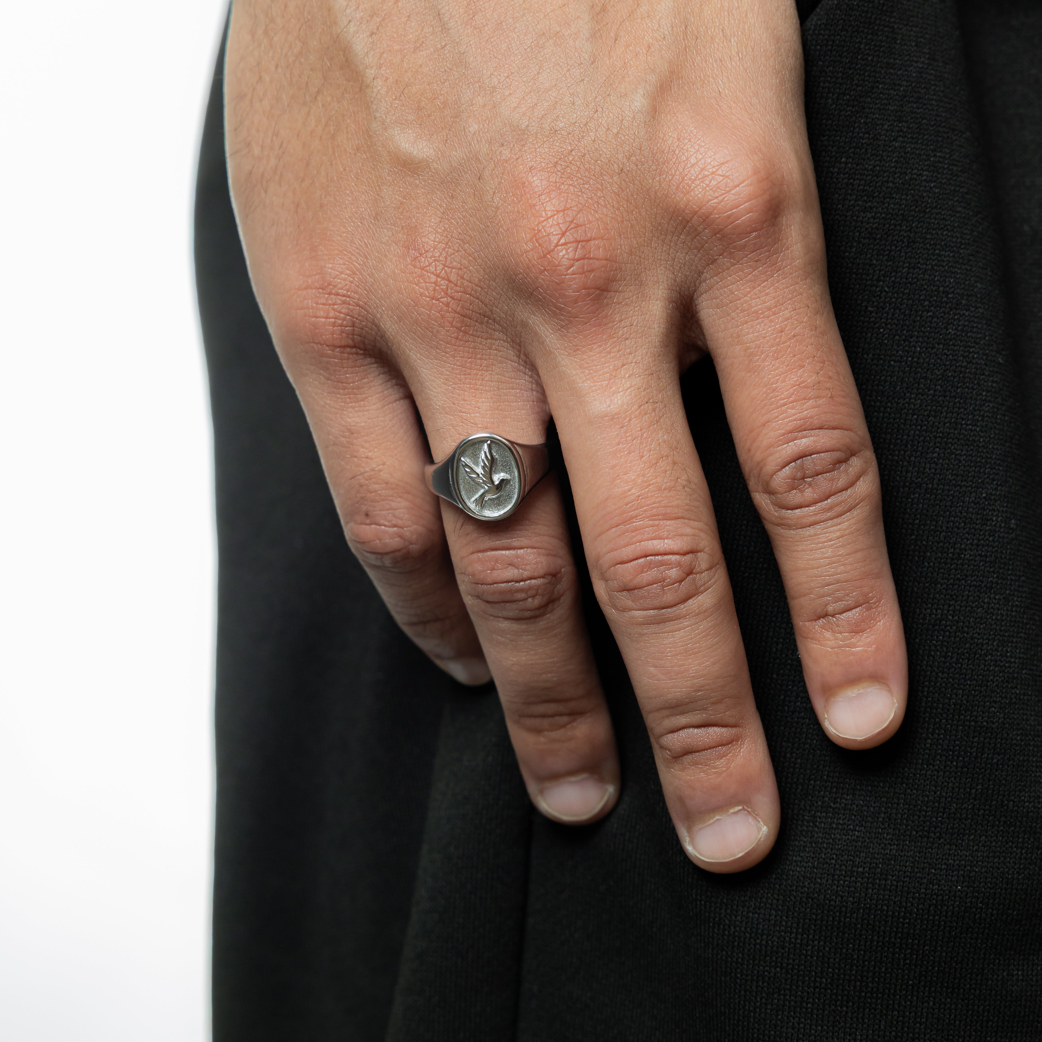 Close-up of mens dove ring showing embossed detailing and stainless steel finish