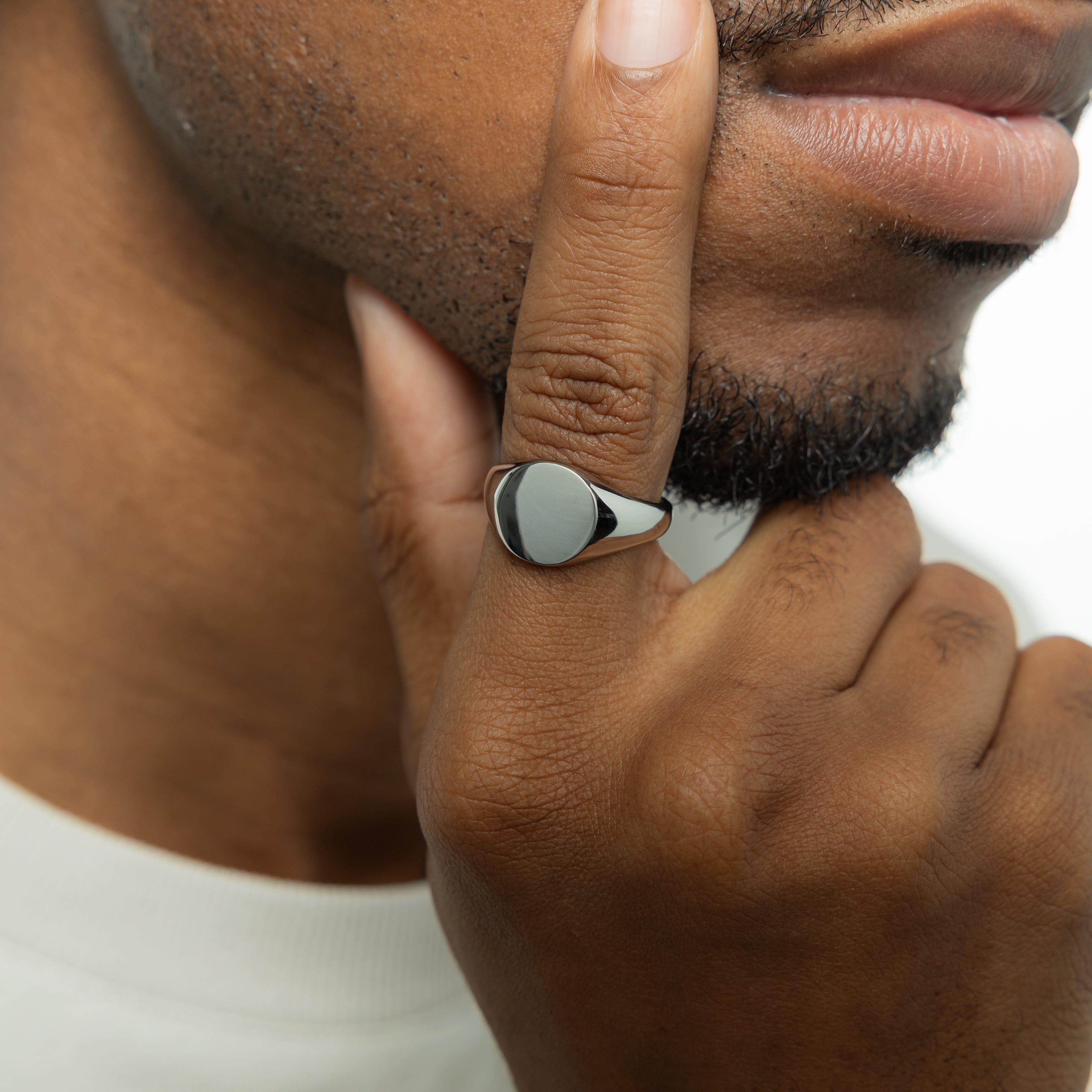 Close-up of the elevated flat top of the stainless steel signet ring, highlighting its smooth finish.
