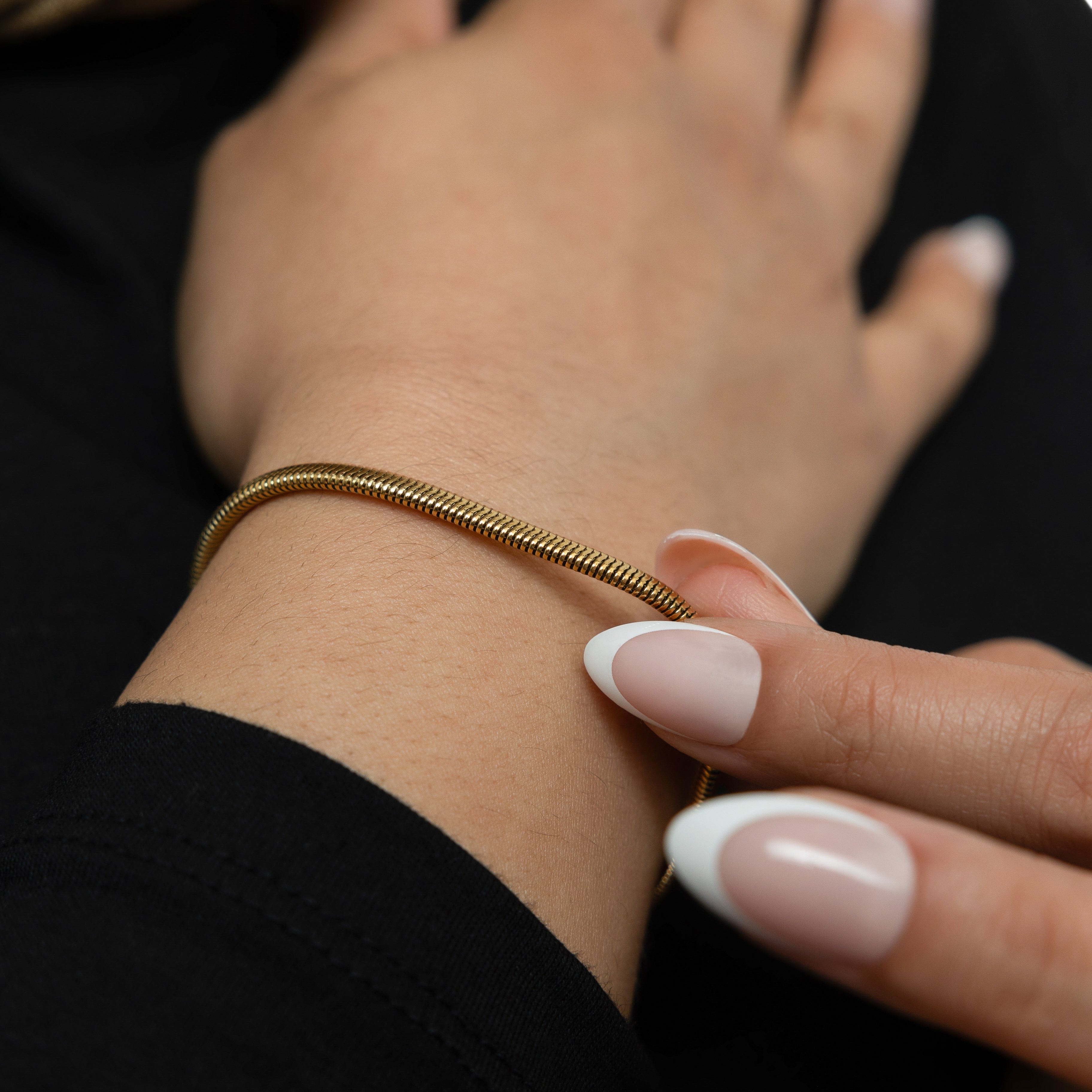 Close-up of the Liquid Gold Rounded Snake Bracelet on a wrist, highlighting its hypoallergenic features.