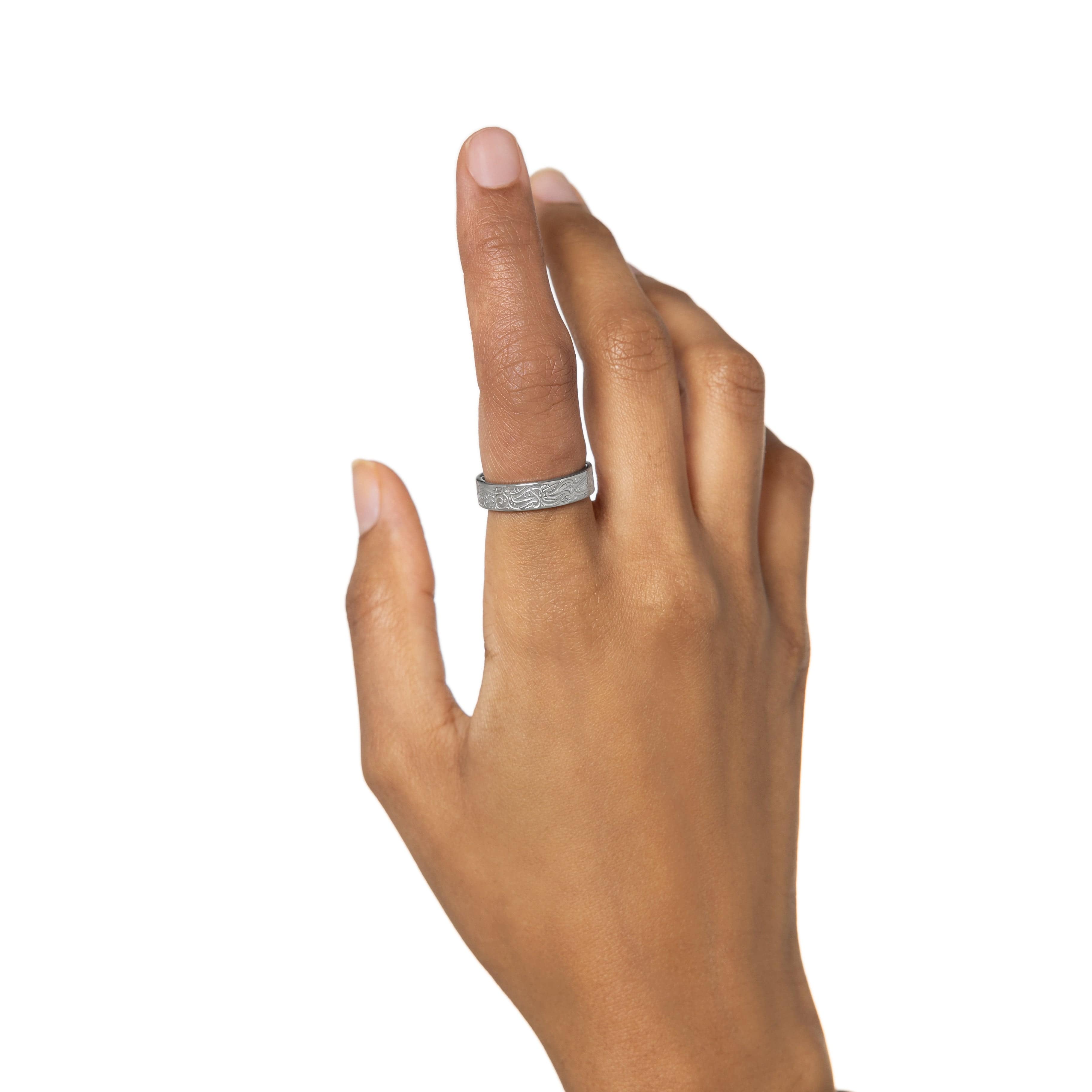 Close-up of the gold plated resilience ring with quote, showing detailed engraving on the outer band.