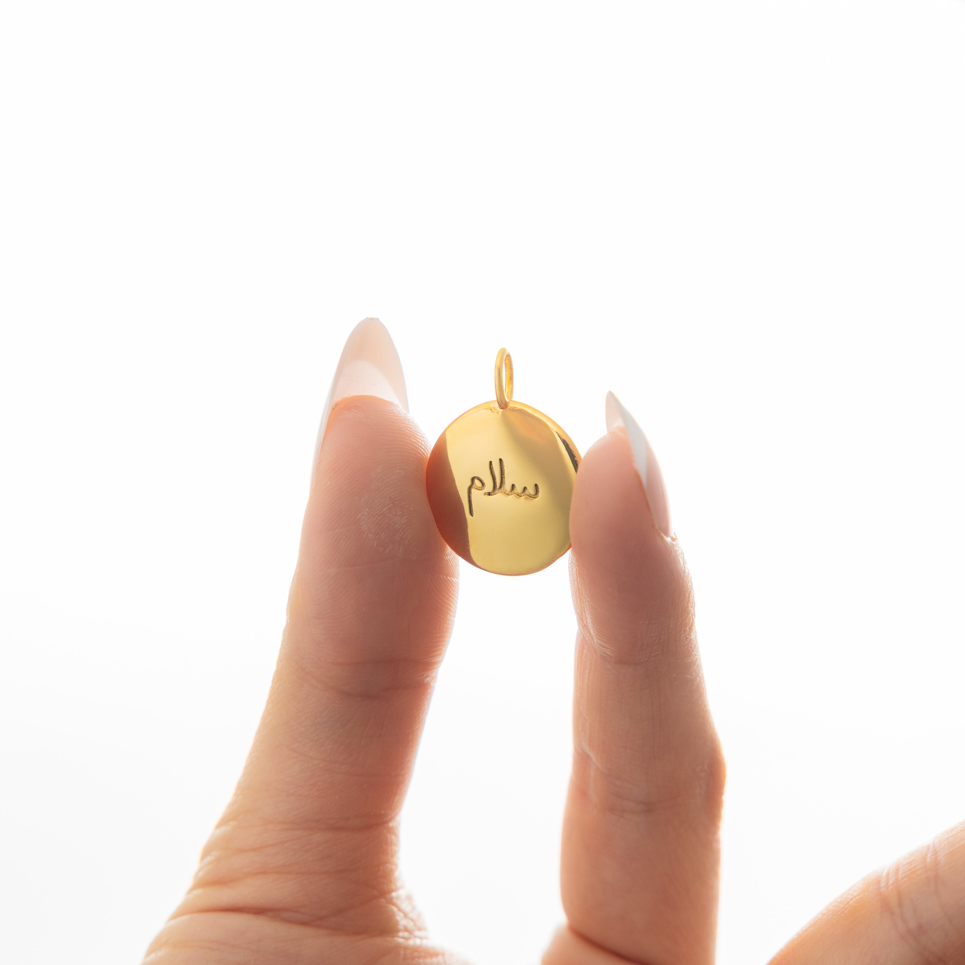 Serenity Gold Charm with Arabic engraving showing peace.