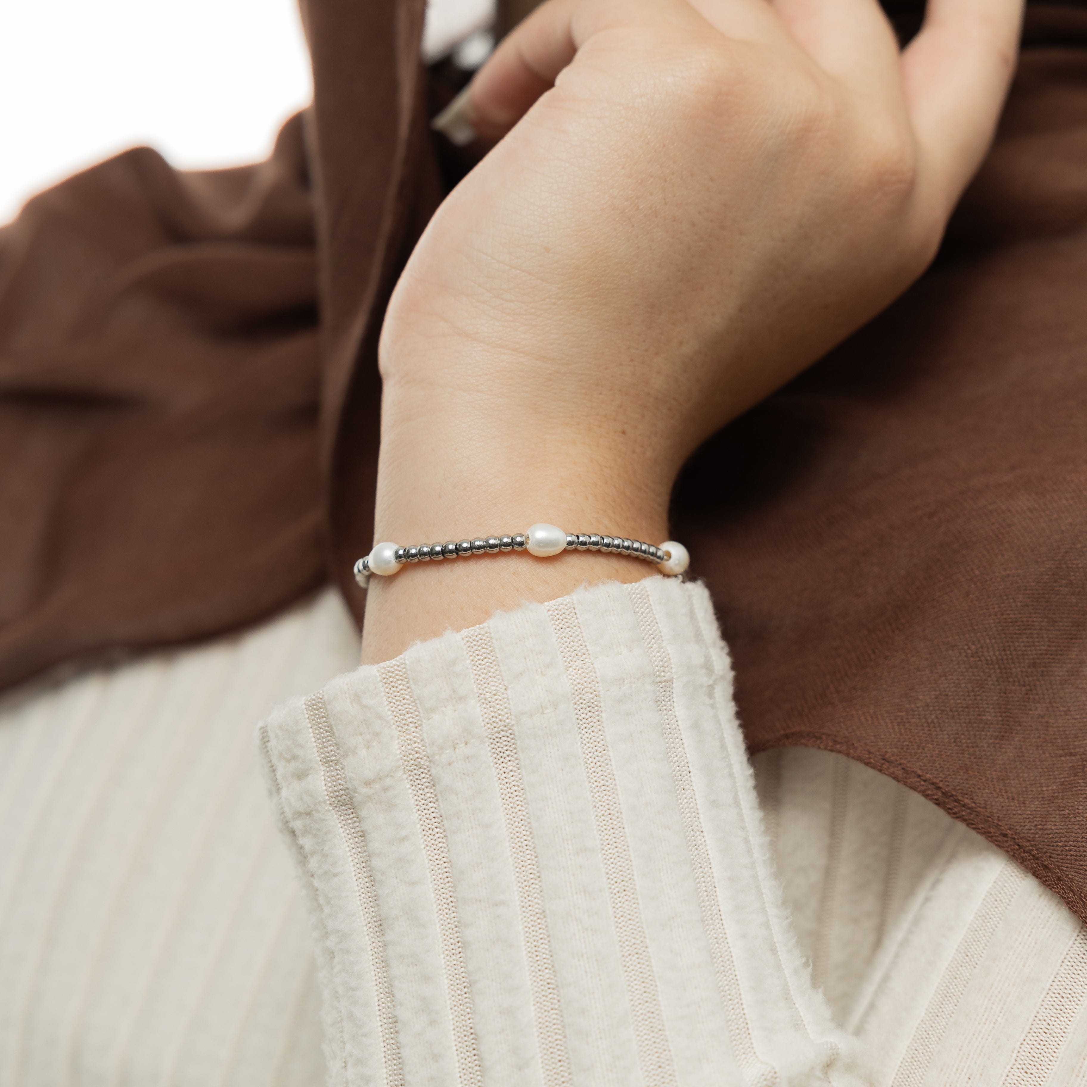Elegant gold pearl bracelet displayed on a wrist, showcasing its beautiful freshwater pearls and gold plating.