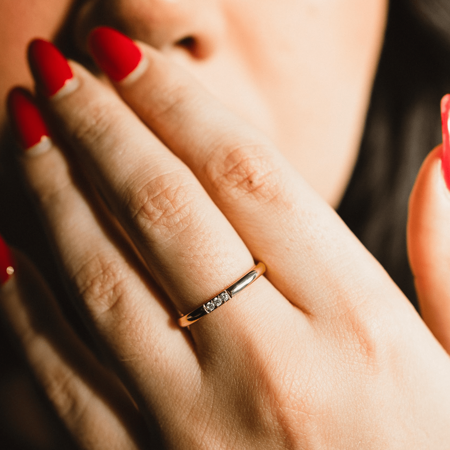 Elegant jewelry piece featuring a triple bezel ring on a womans hand.