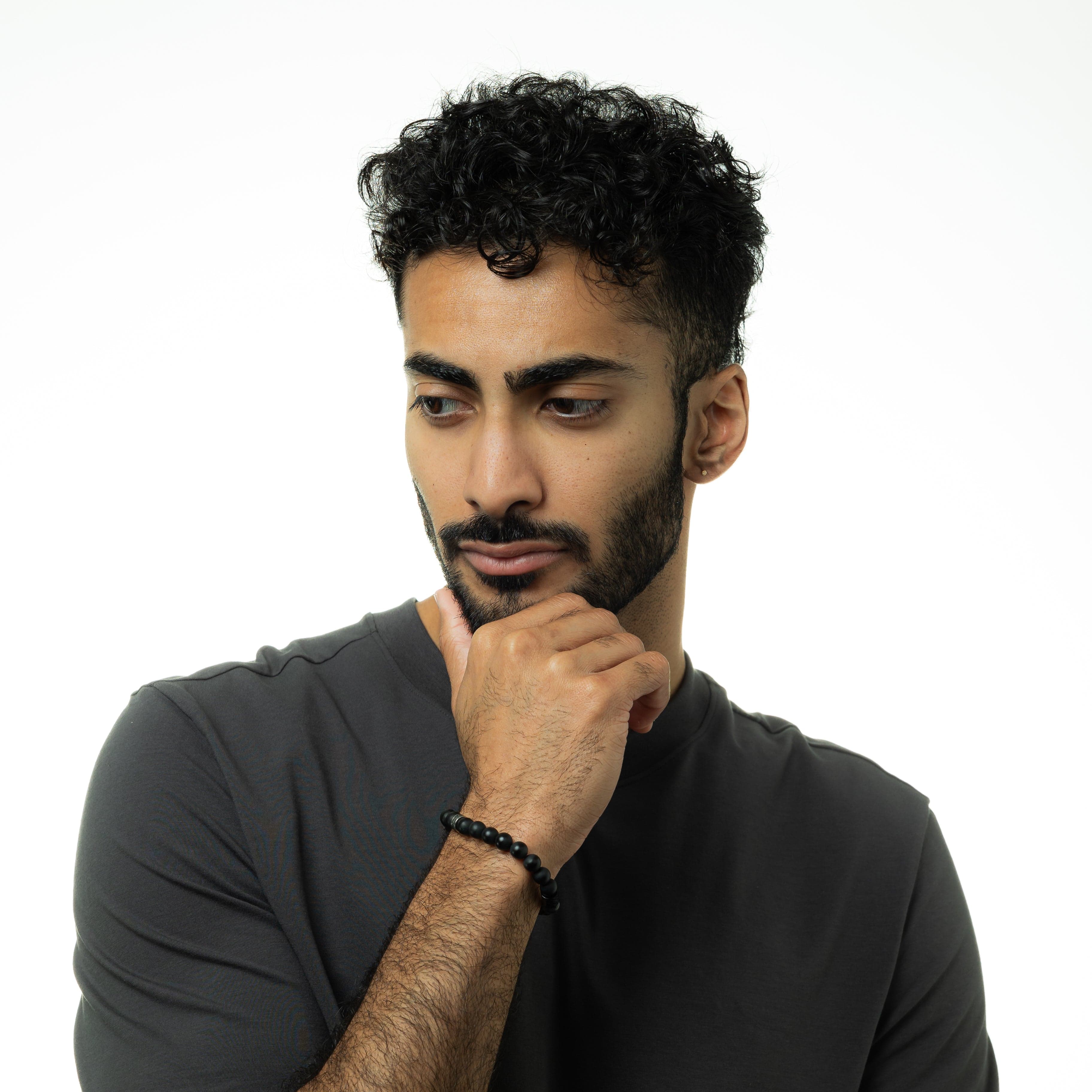 Model wearing the Cosmic Matte Black Stone Bracelet, highlighting its versatility with different outfits.