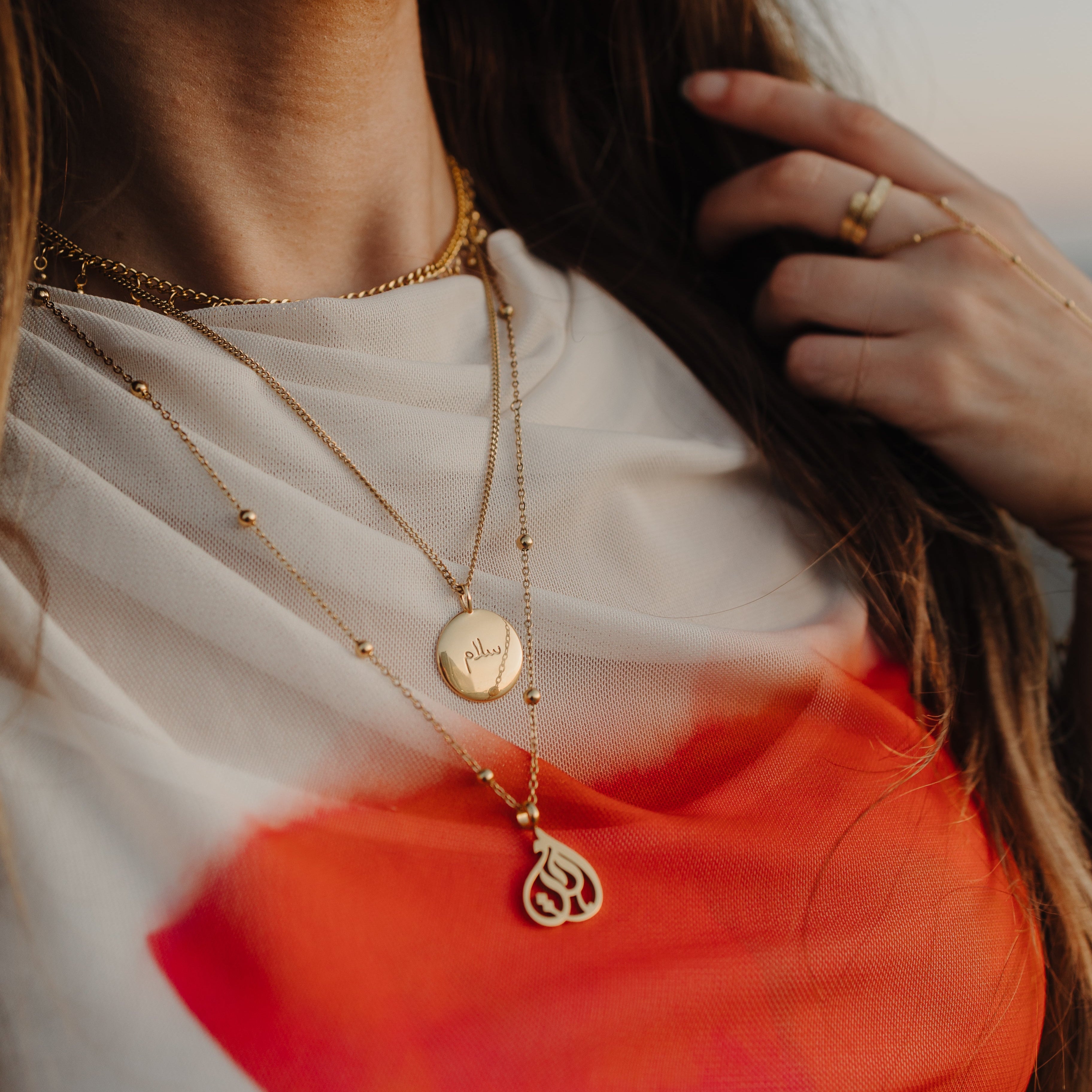 Personalized charm necklace displayed on a minimalist background.