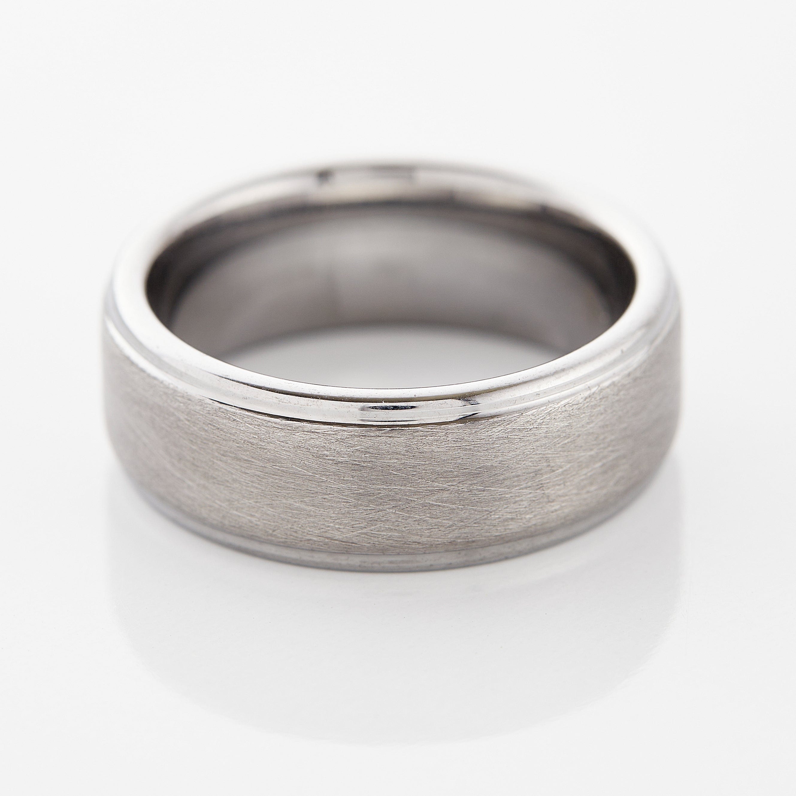 Close-up view of the textured tungsten wedding band, highlighting its rugged finish.