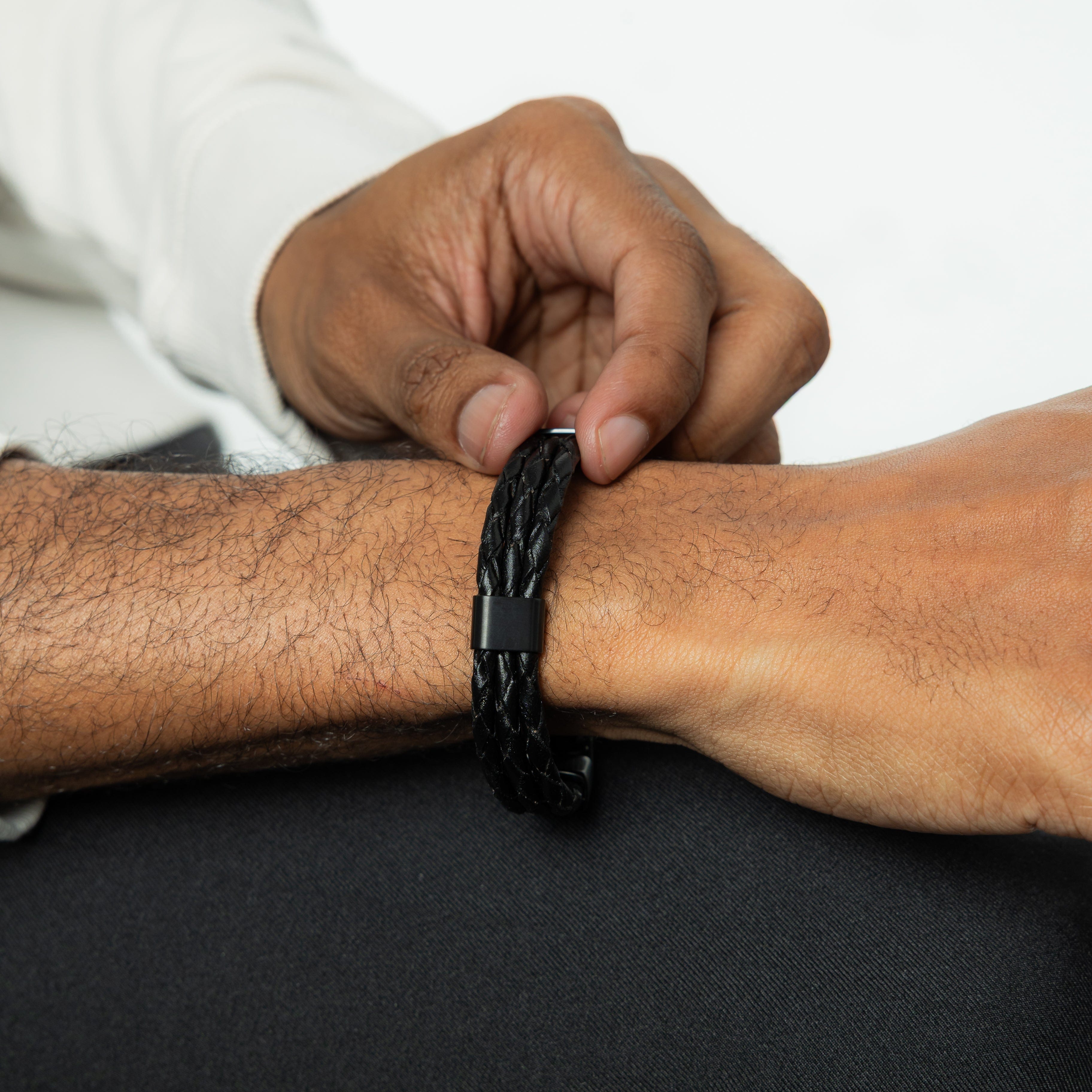 The stylish leather bracelet for men displayed on a wrist in a casual setting.