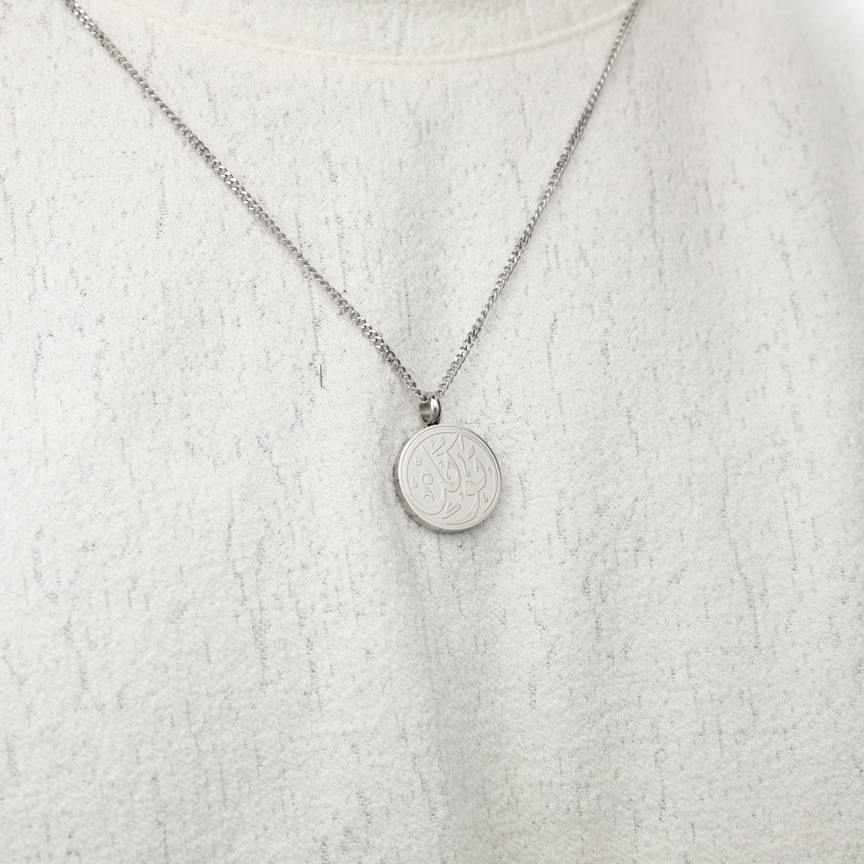 Men wearing a stylish trust pendant with Arabic calligraphy in various settings.