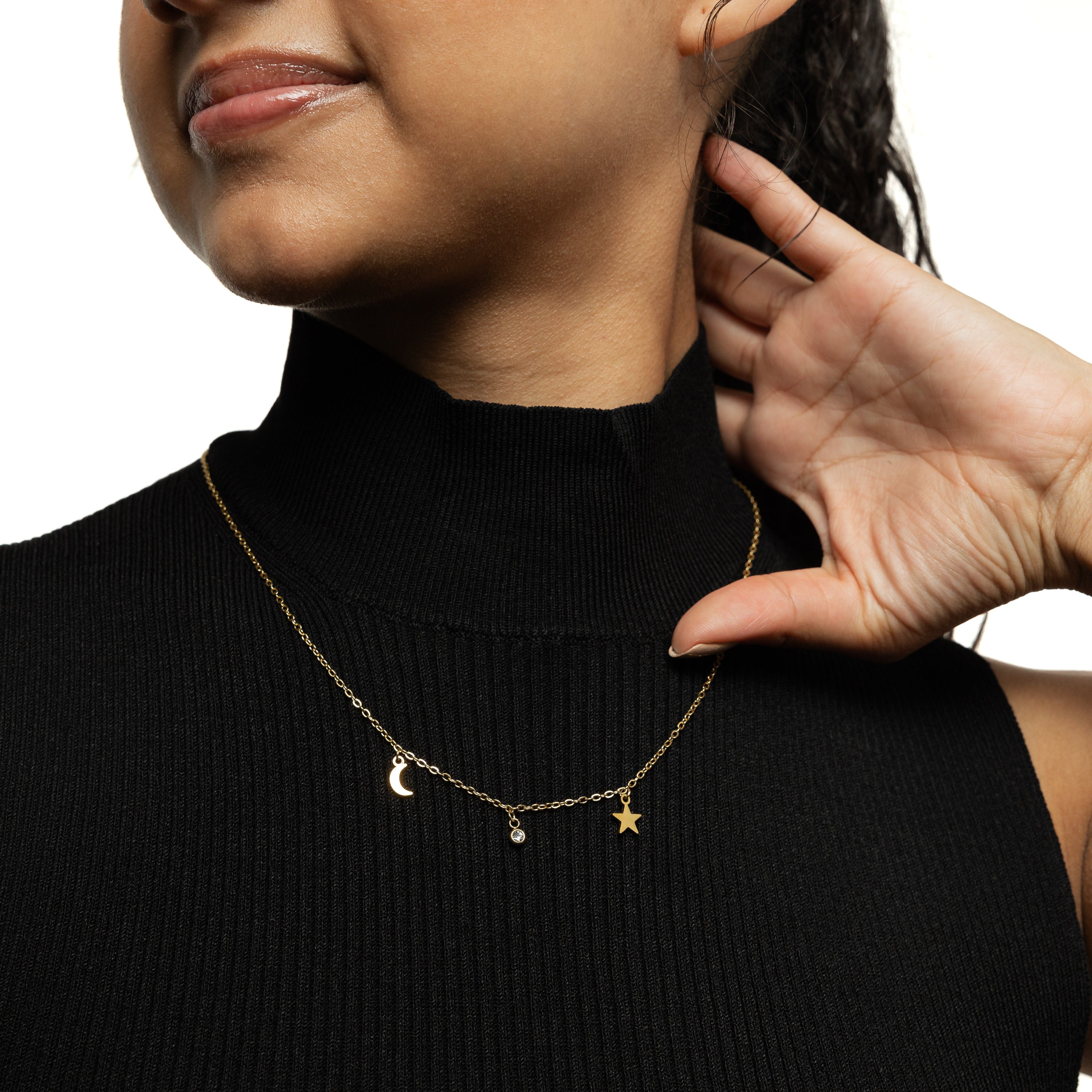 Model wearing the gold celestial necklace layered with other simple chains for a trendy look.