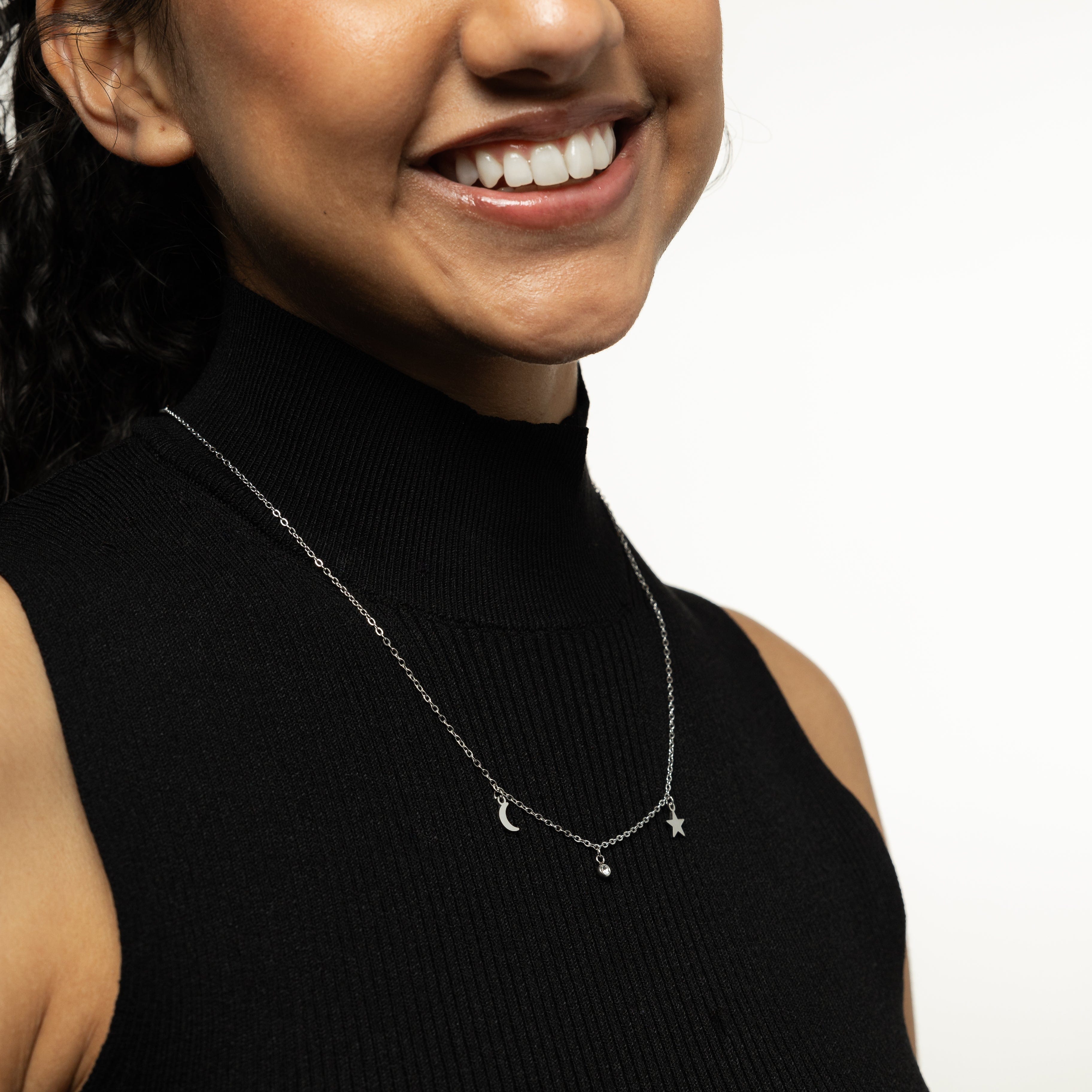 Close-up of the gold celestial necklace showcasing its moon pendant in natural light.