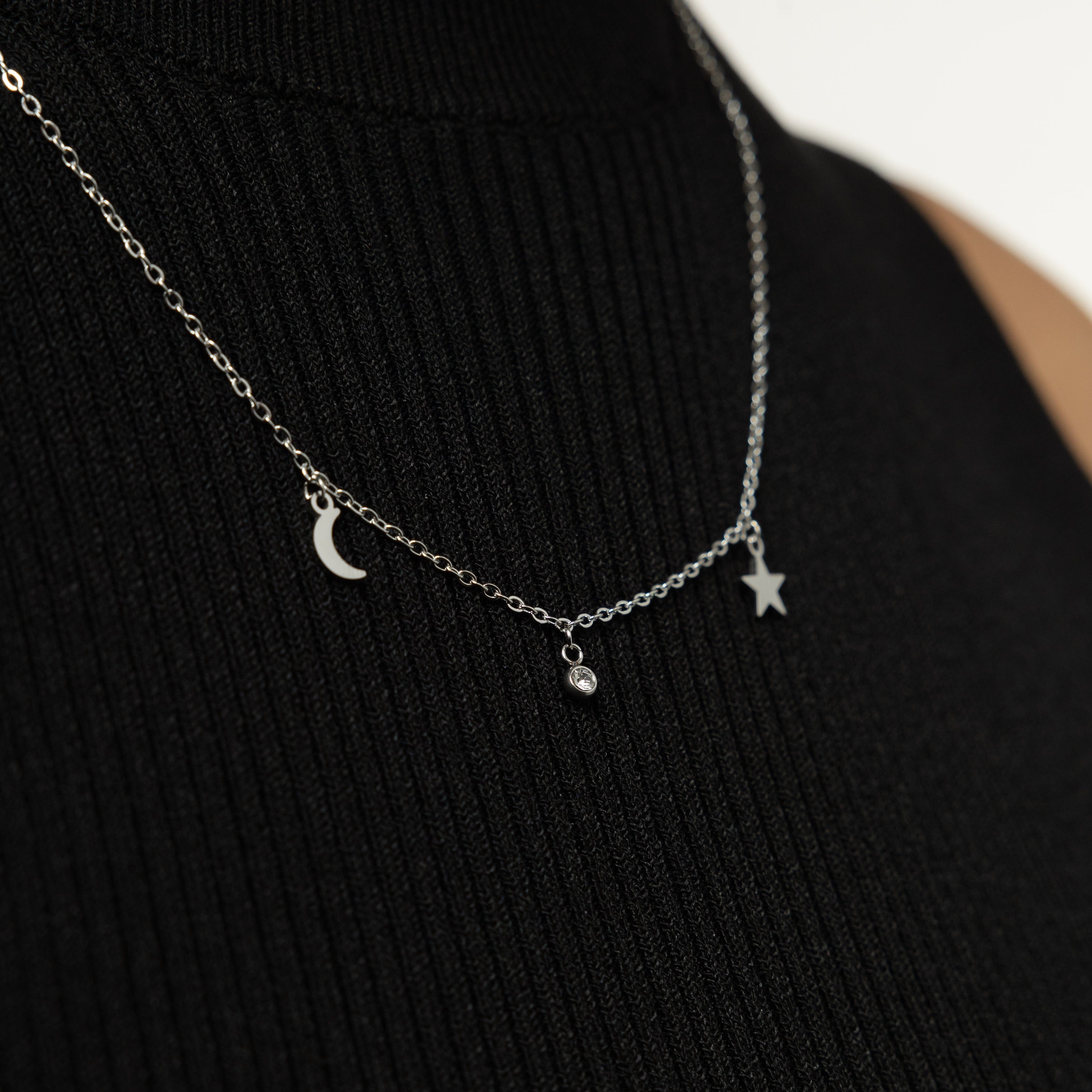 Model wearing the gold celestial necklace layered with other simple chains for a trendy look.