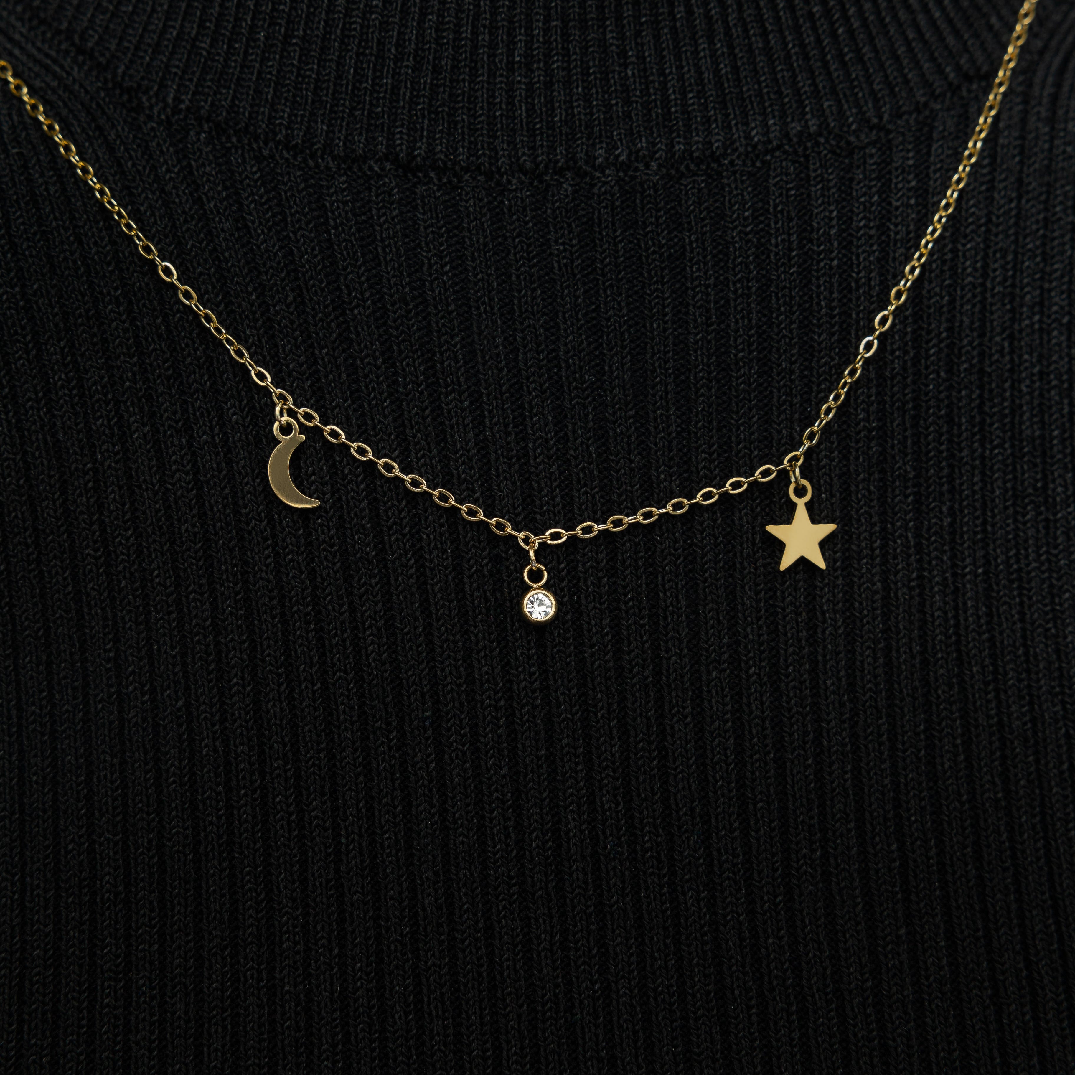 Model wearing the gold celestial necklace layered with other simple chains for a trendy look.