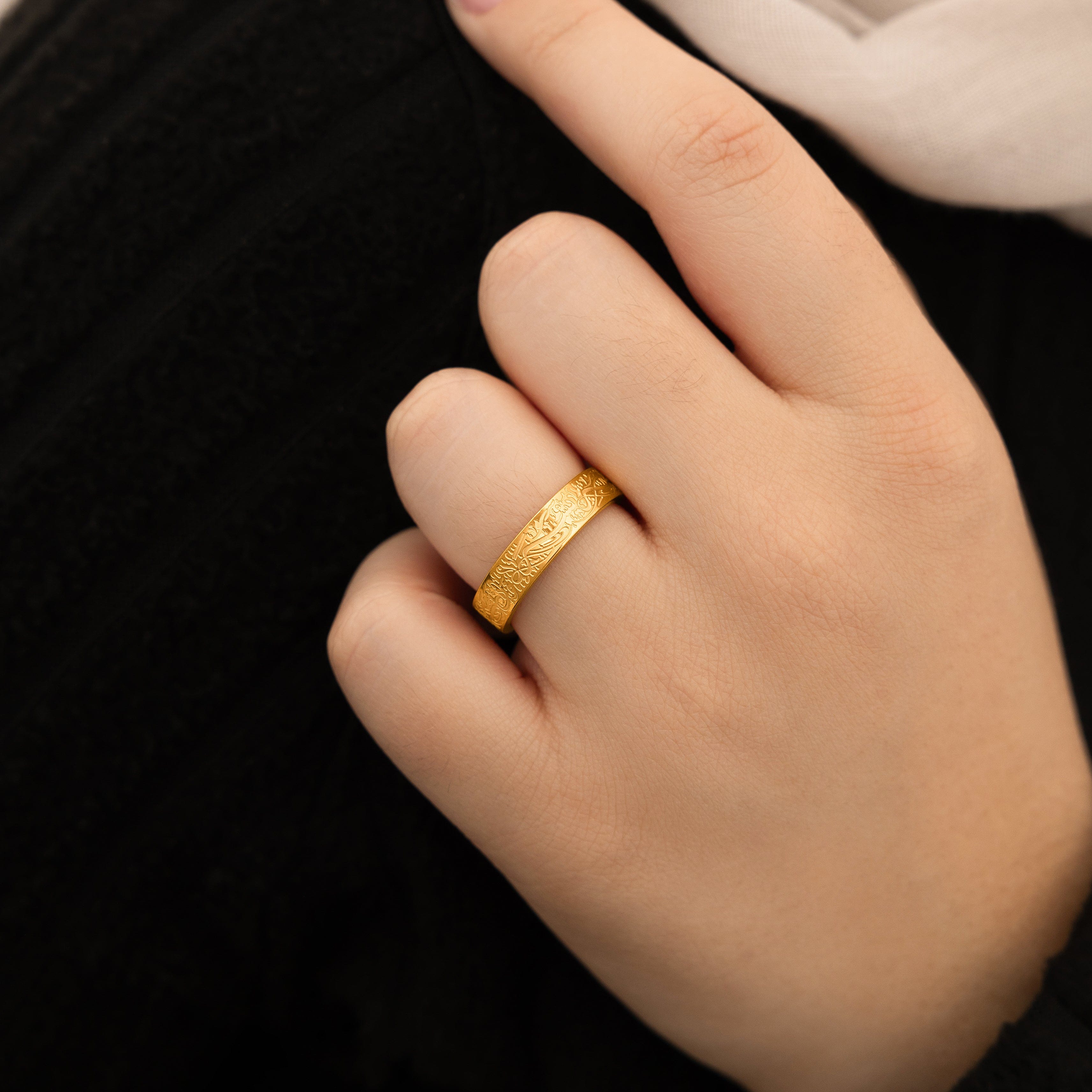 Close-up of the engraved gold ring highlighting the detailed Arabic script.