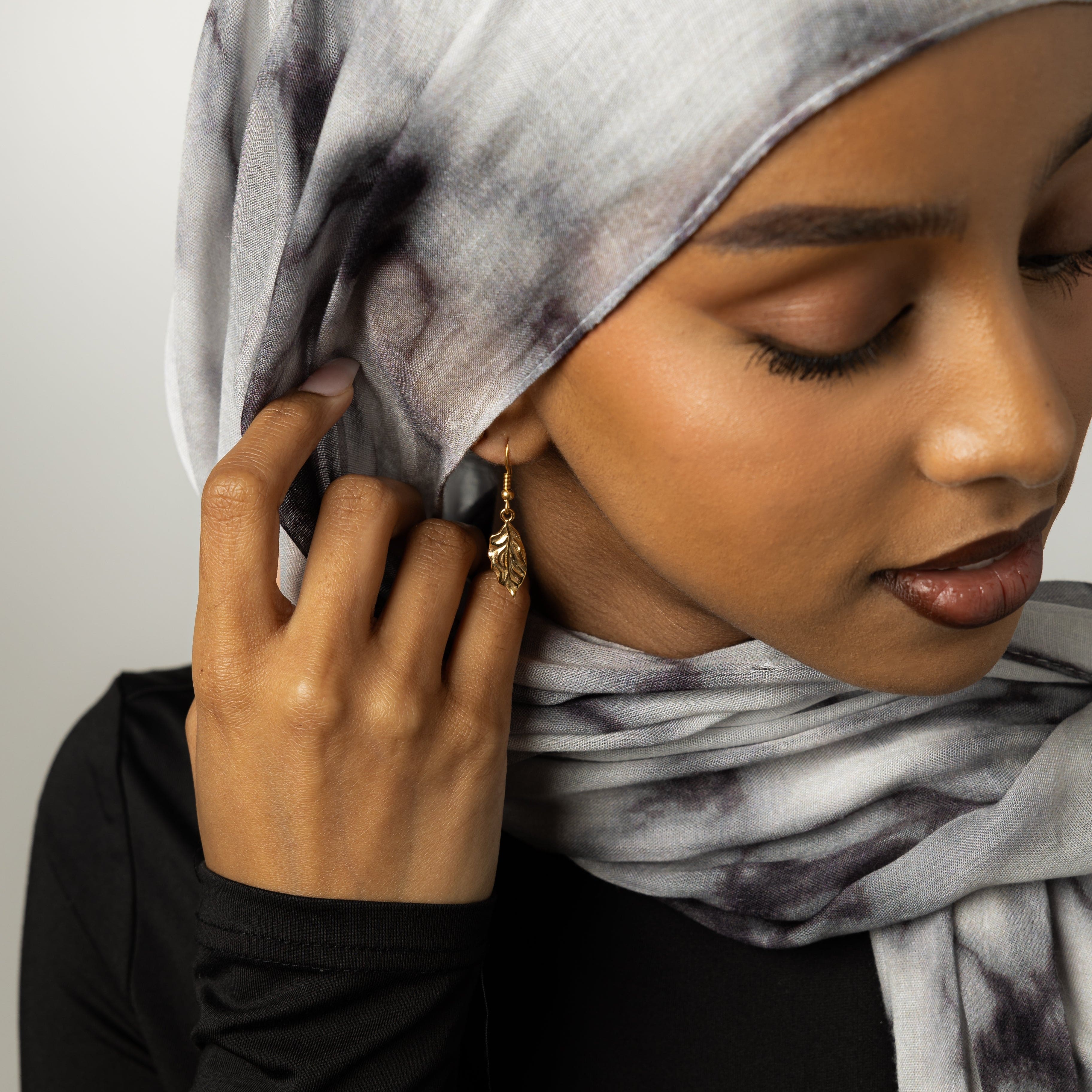 Close-up of vintage leaf earrings showcasing the intricate gold flaked design.