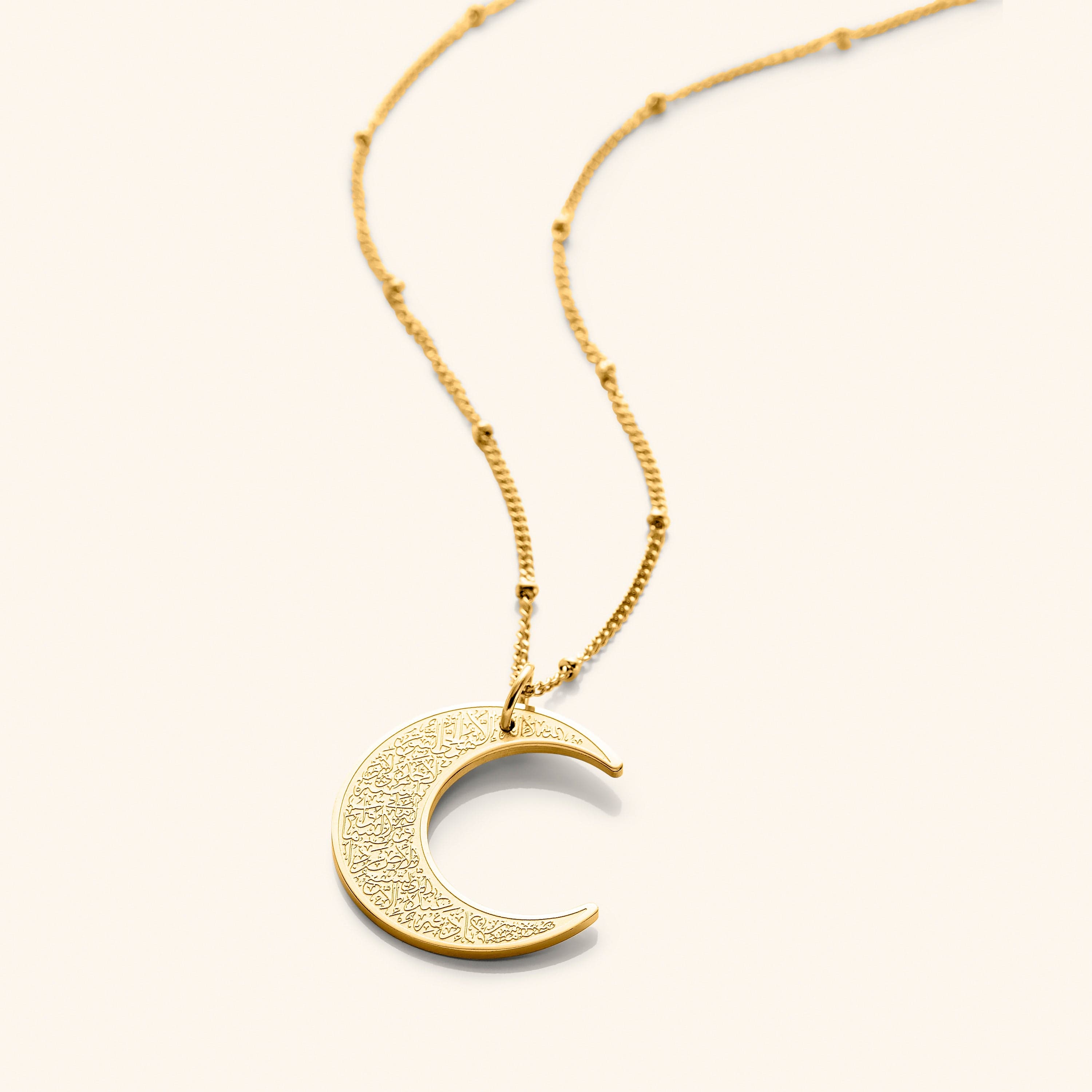 Close-up of the Ayatul Kursi crescent necklace showcasing detailed engravings.