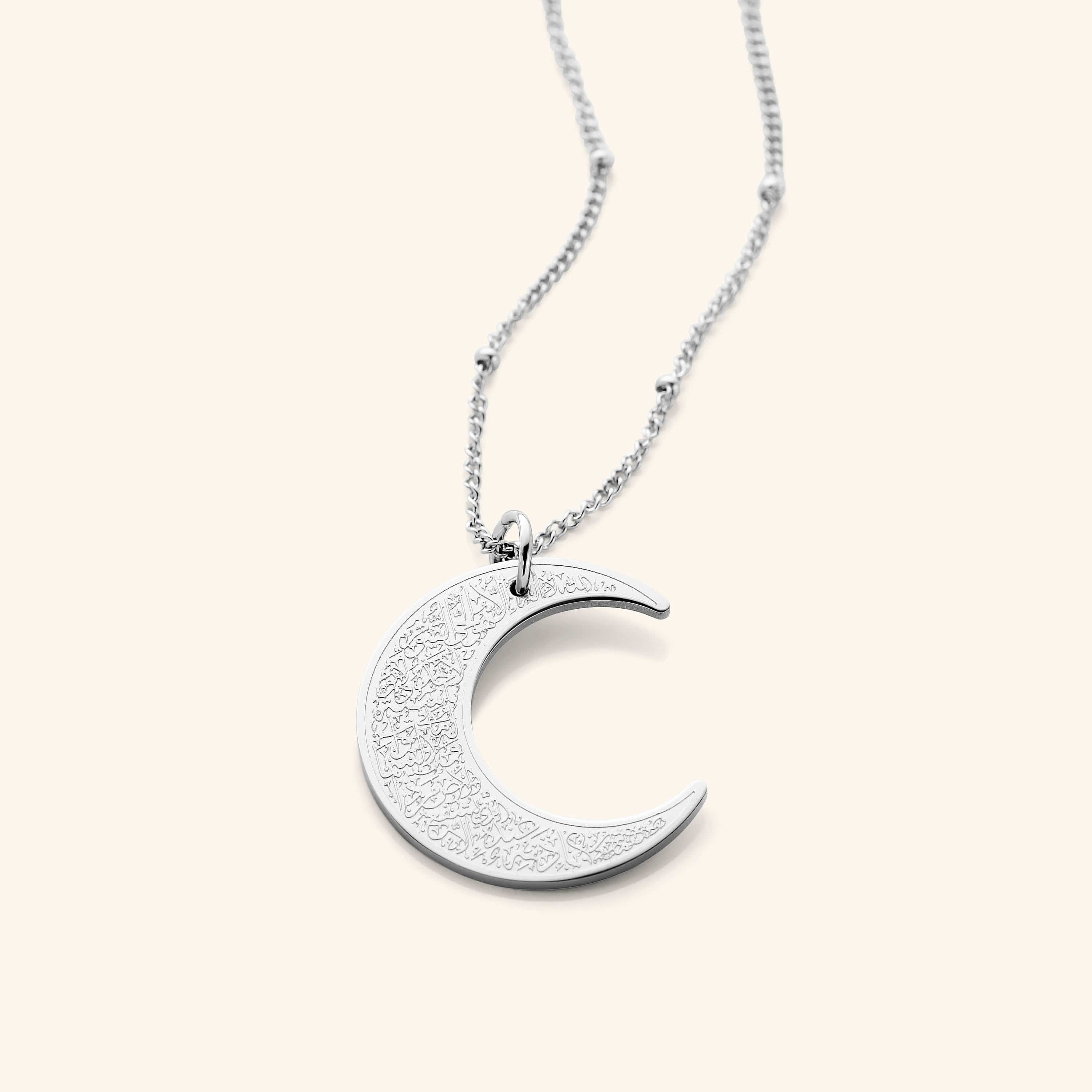 Close-up of the Ayatul Kursi crescent necklace showcasing detailed engravings.