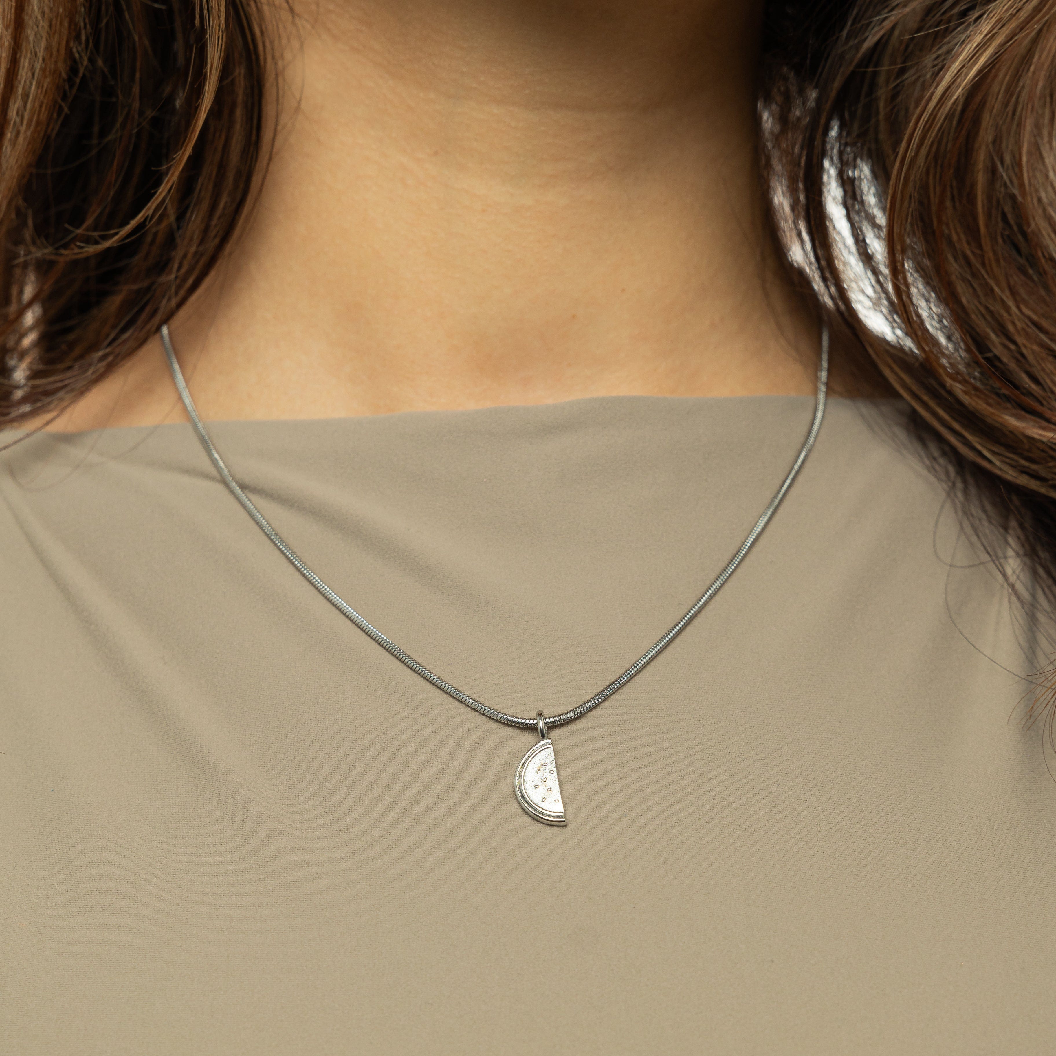 Model wearing the watermelon necklace, styled with casual attire for a chic look.
