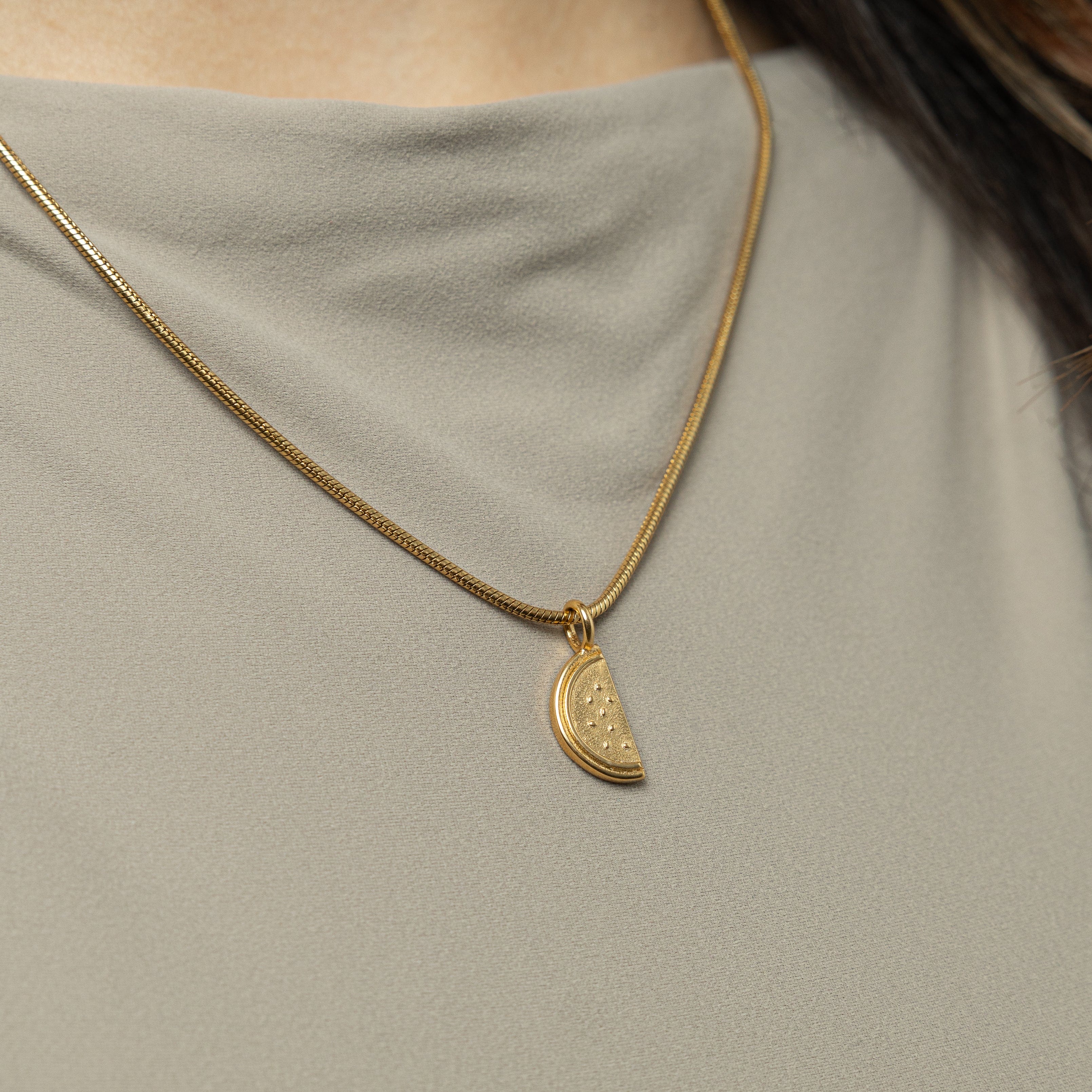 Model wearing the watermelon necklace, styled with casual attire for a chic look.