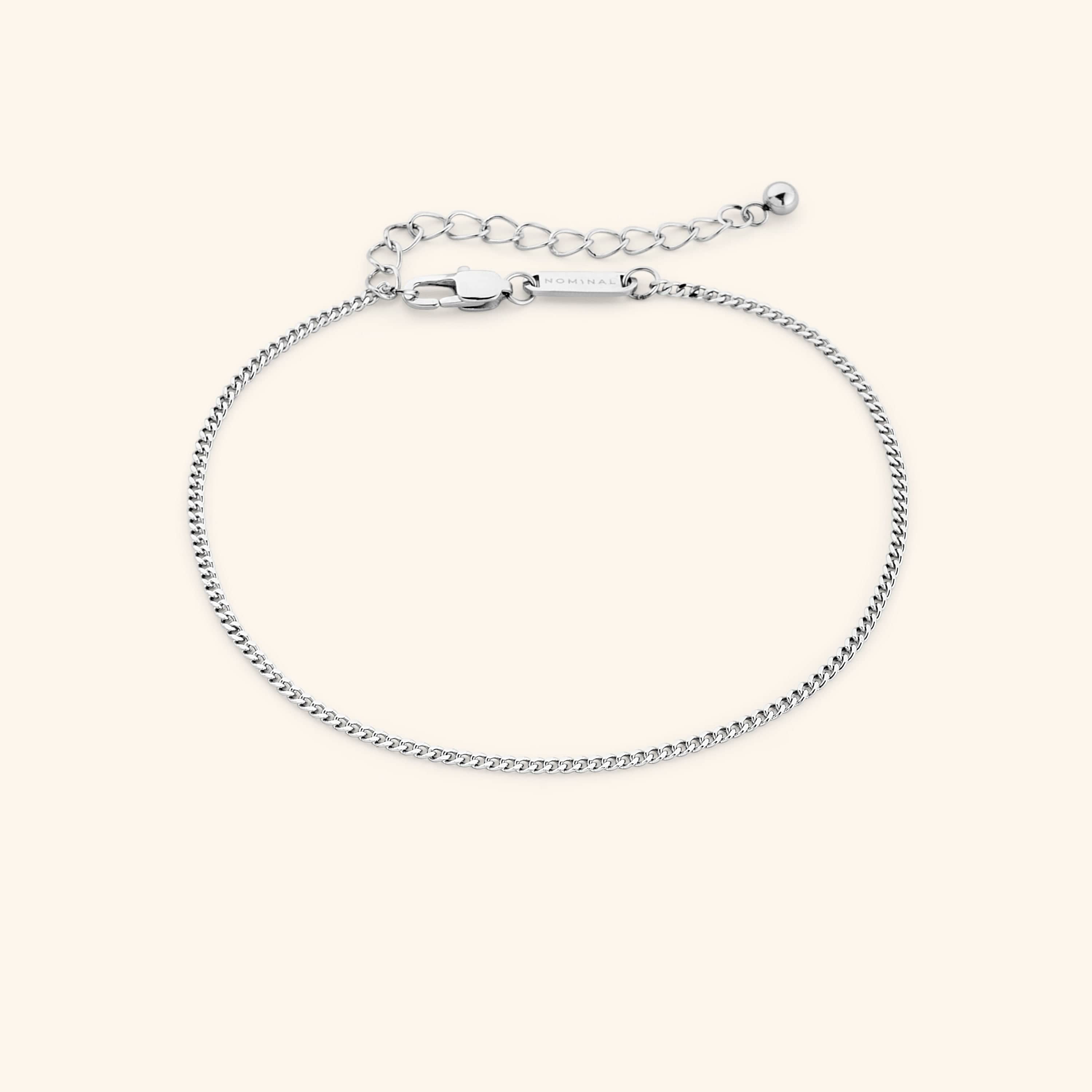 Curb chain anklet displayed in a velvet drawstring pouch.
