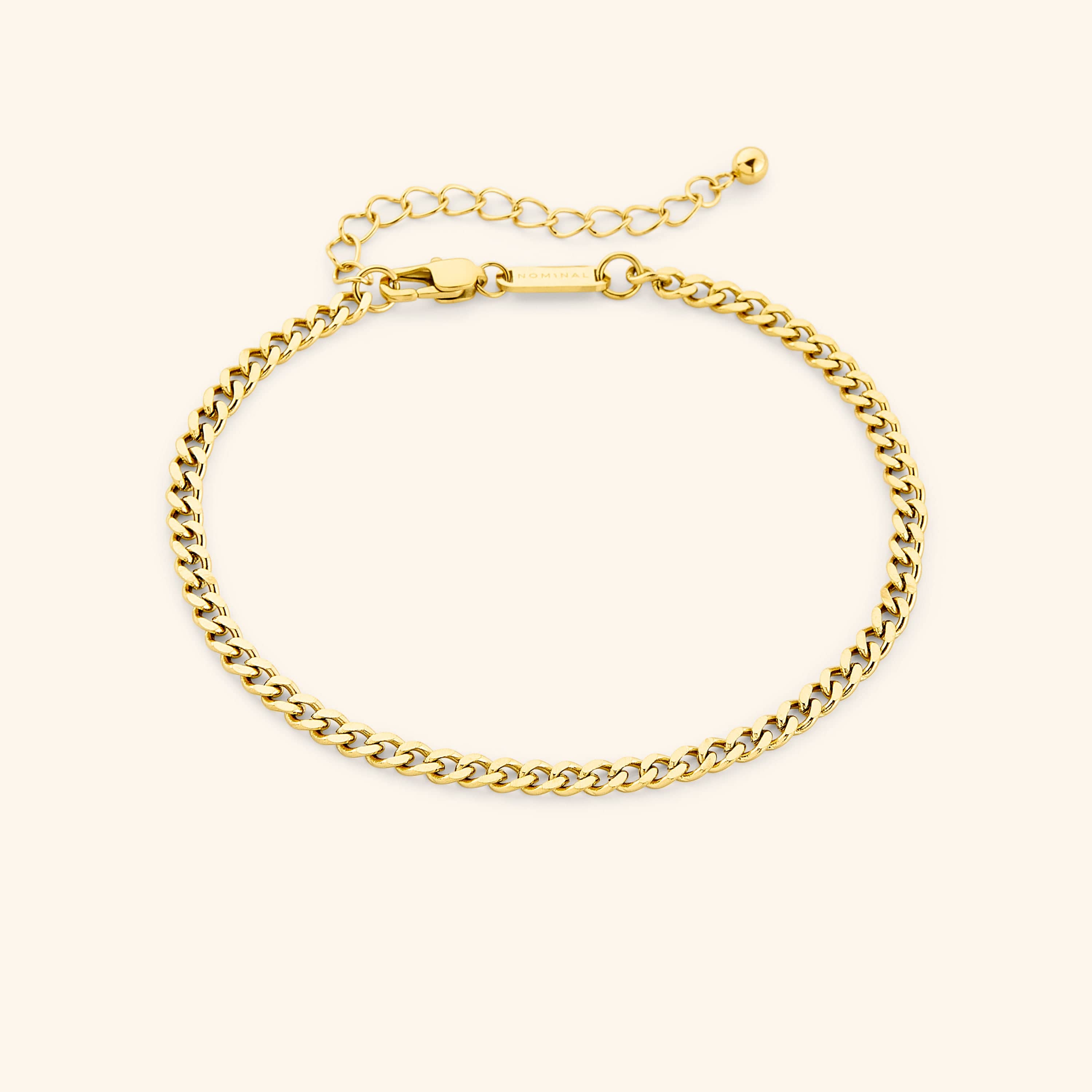 Curb chain anklet displayed in a velvet drawstring pouch.