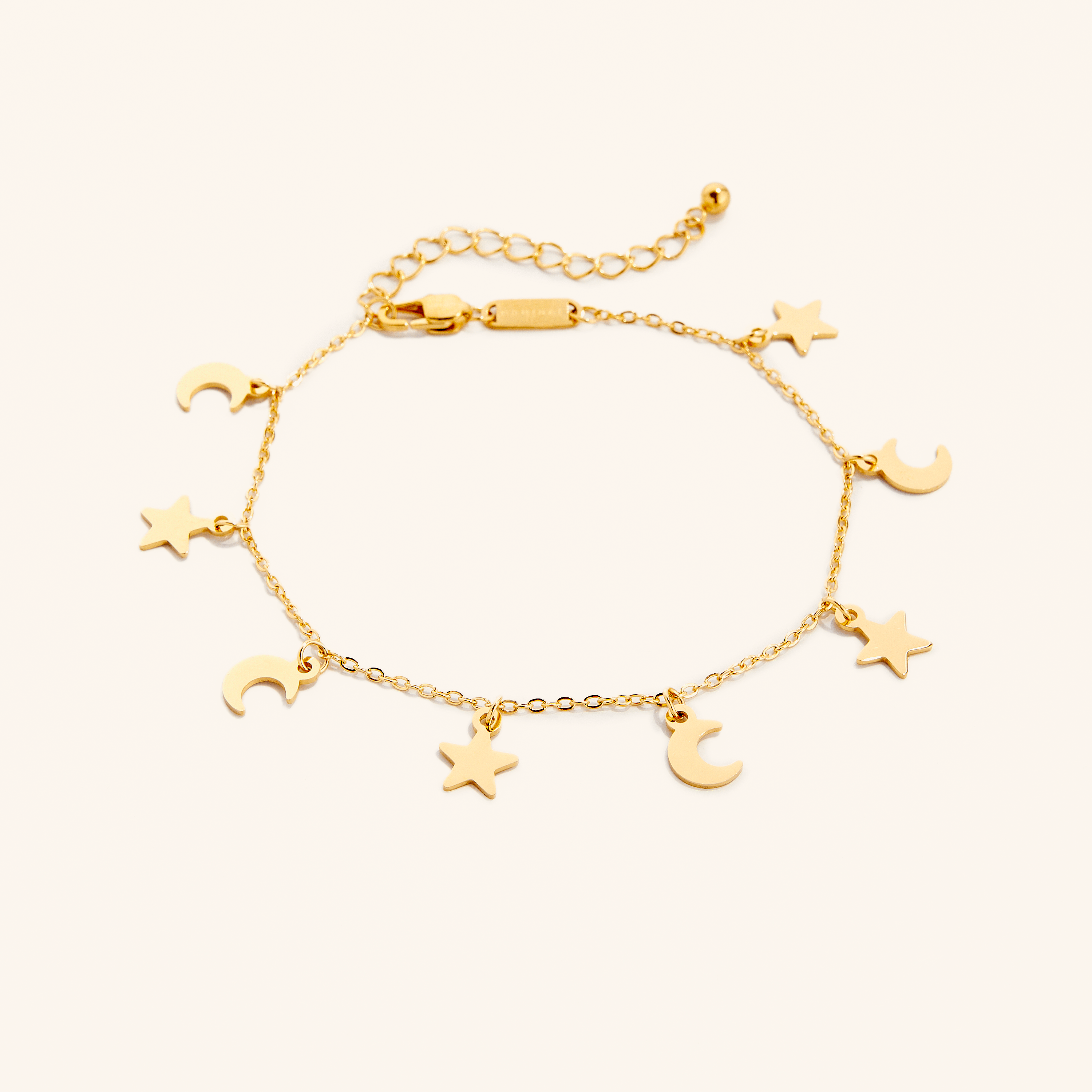 Close-up of gold anklet with celestial charm detail shown on ankle in soft natural light