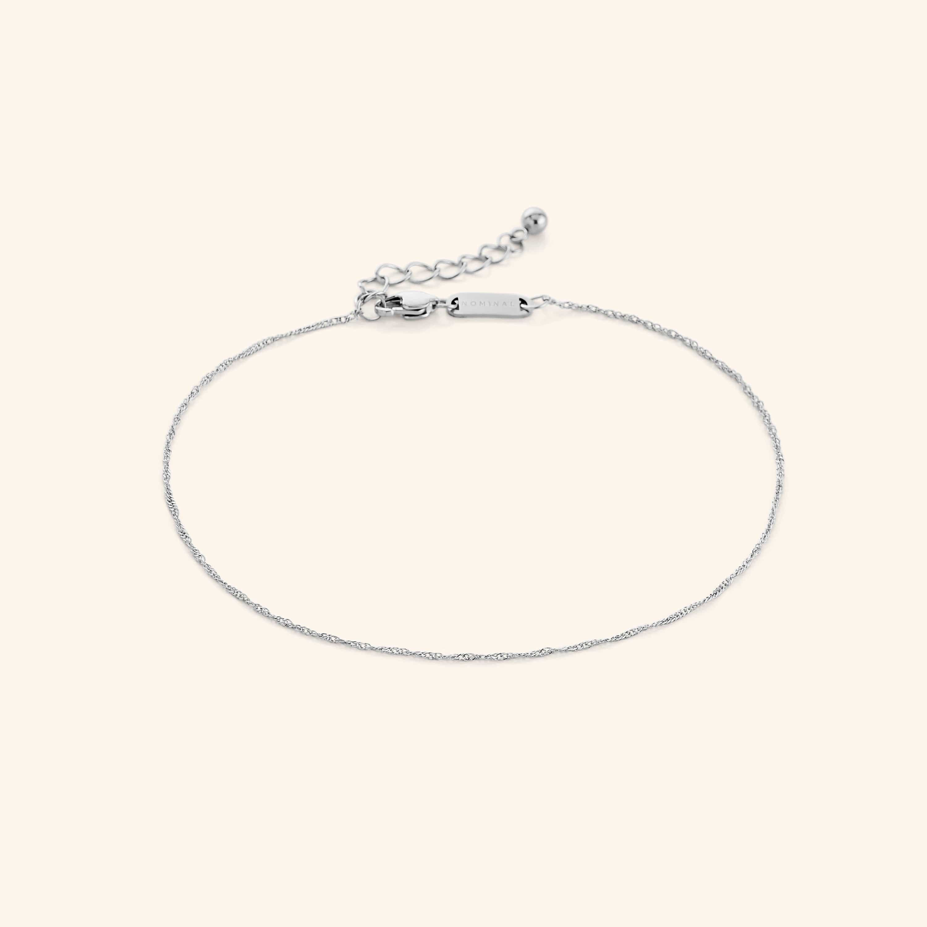 Close-up of the micro twisted gold anklet laid flat on velvet pouch