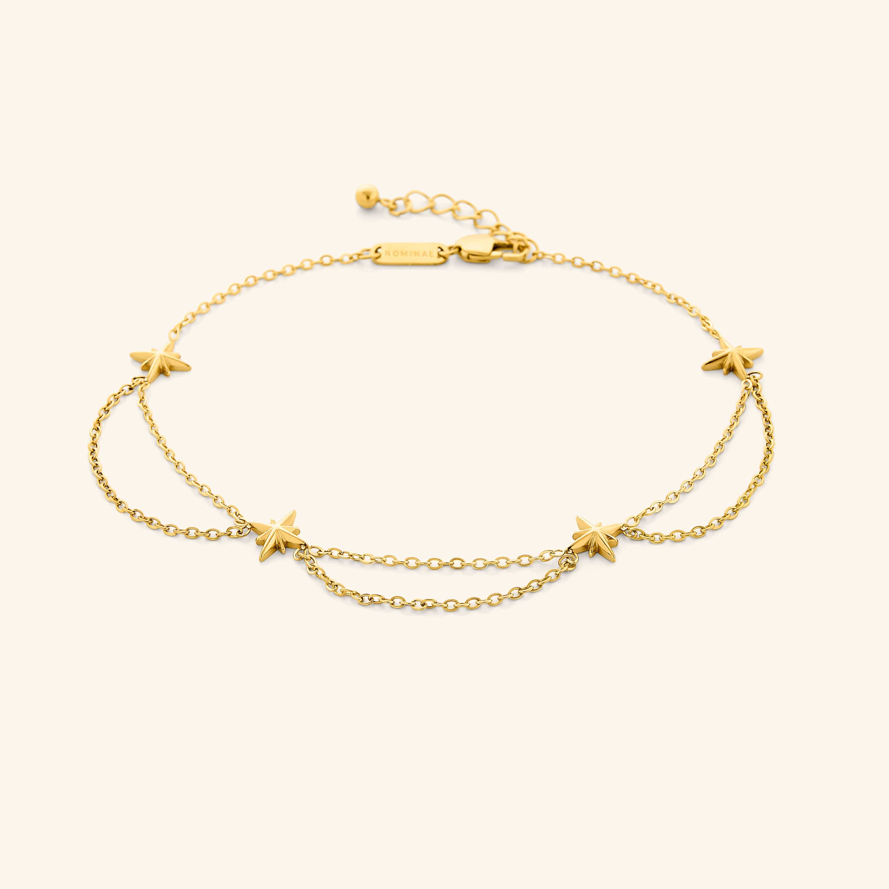 Close-up of the Guiding Star Gold Anklet showing detailed charms and chain design.