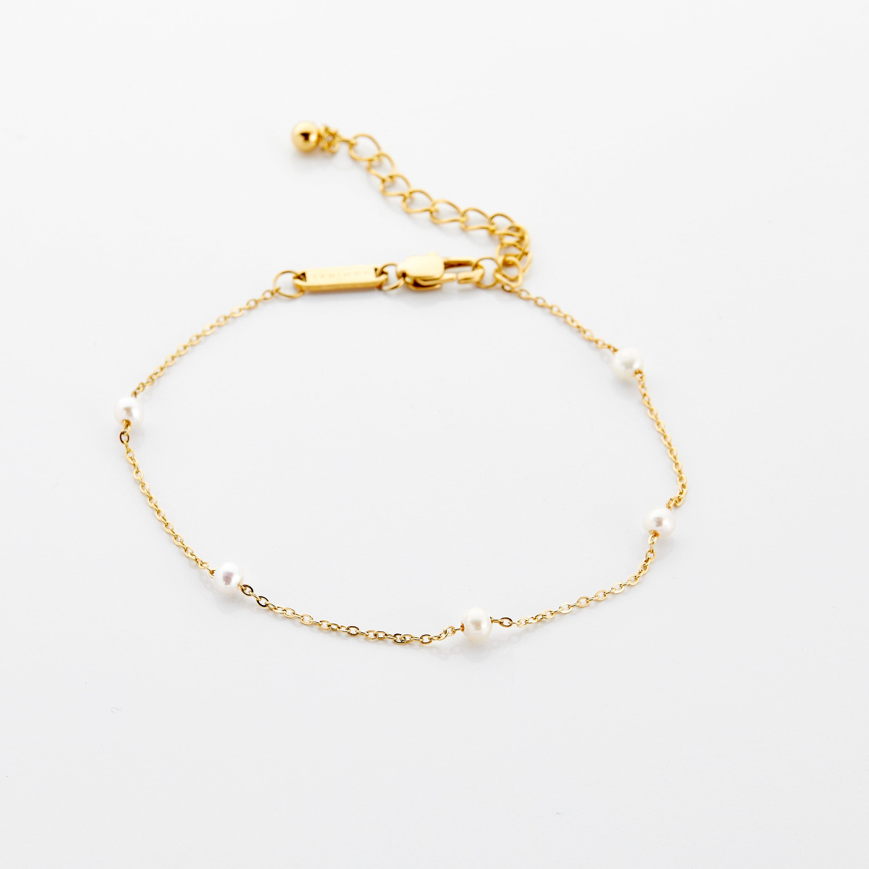 Close-up of an elegant pearl strand anklet showcasing fresh water pearls and gold plating.