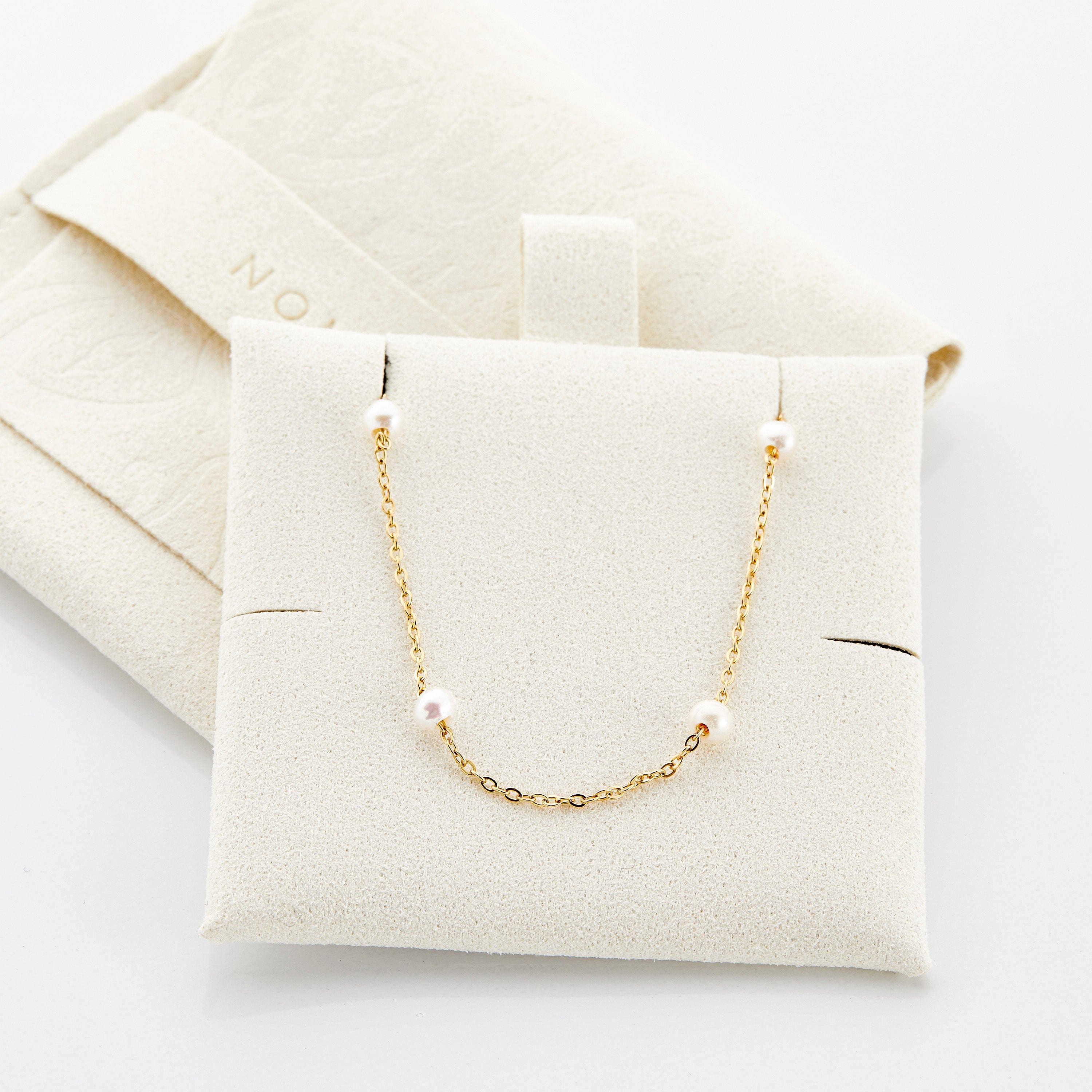 The elegant pearl strand anklet displayed in a velvet pouch, ideal for gifting or personal use.