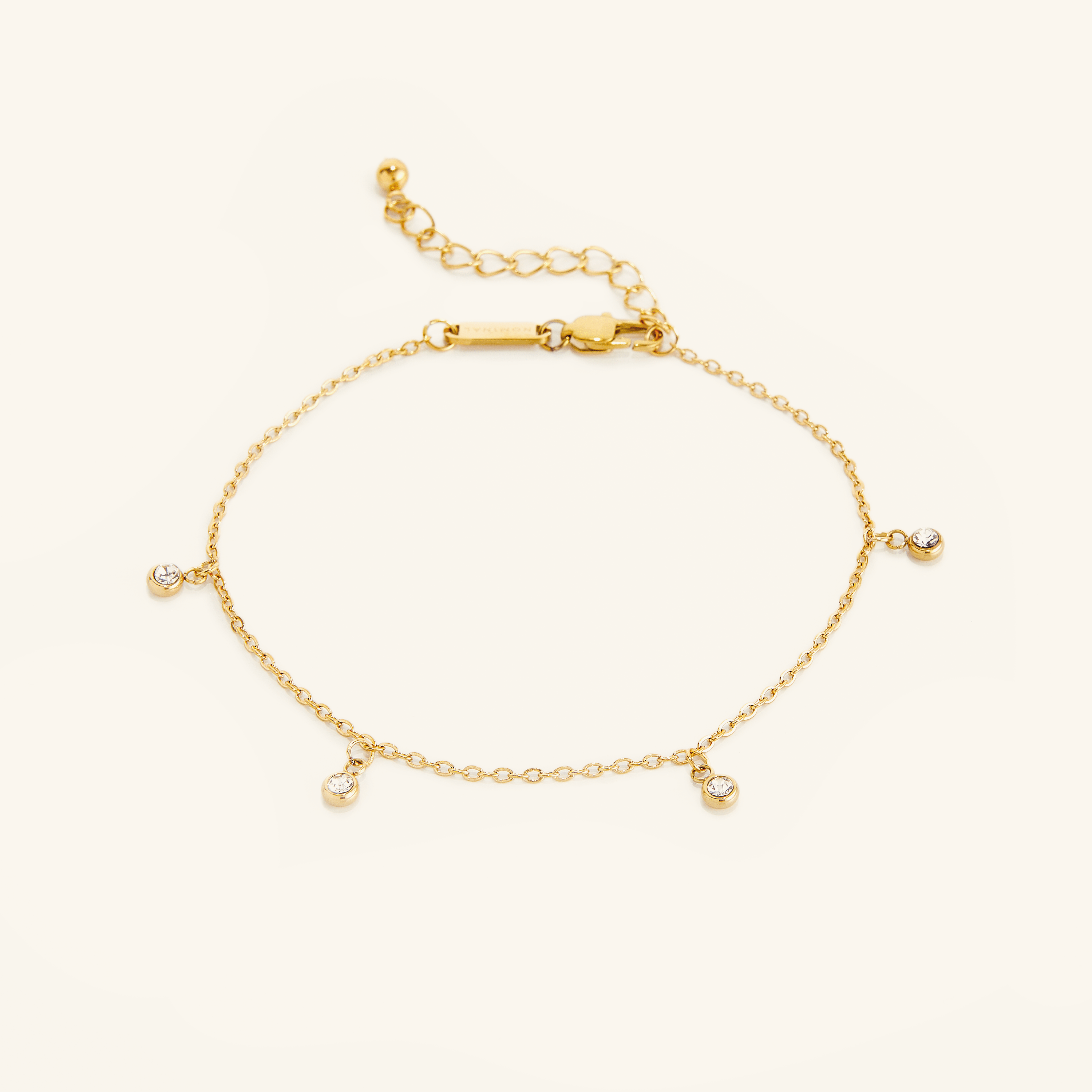 Close-up of the elegant gold bezel anklet showcasing its intricate design and gems.