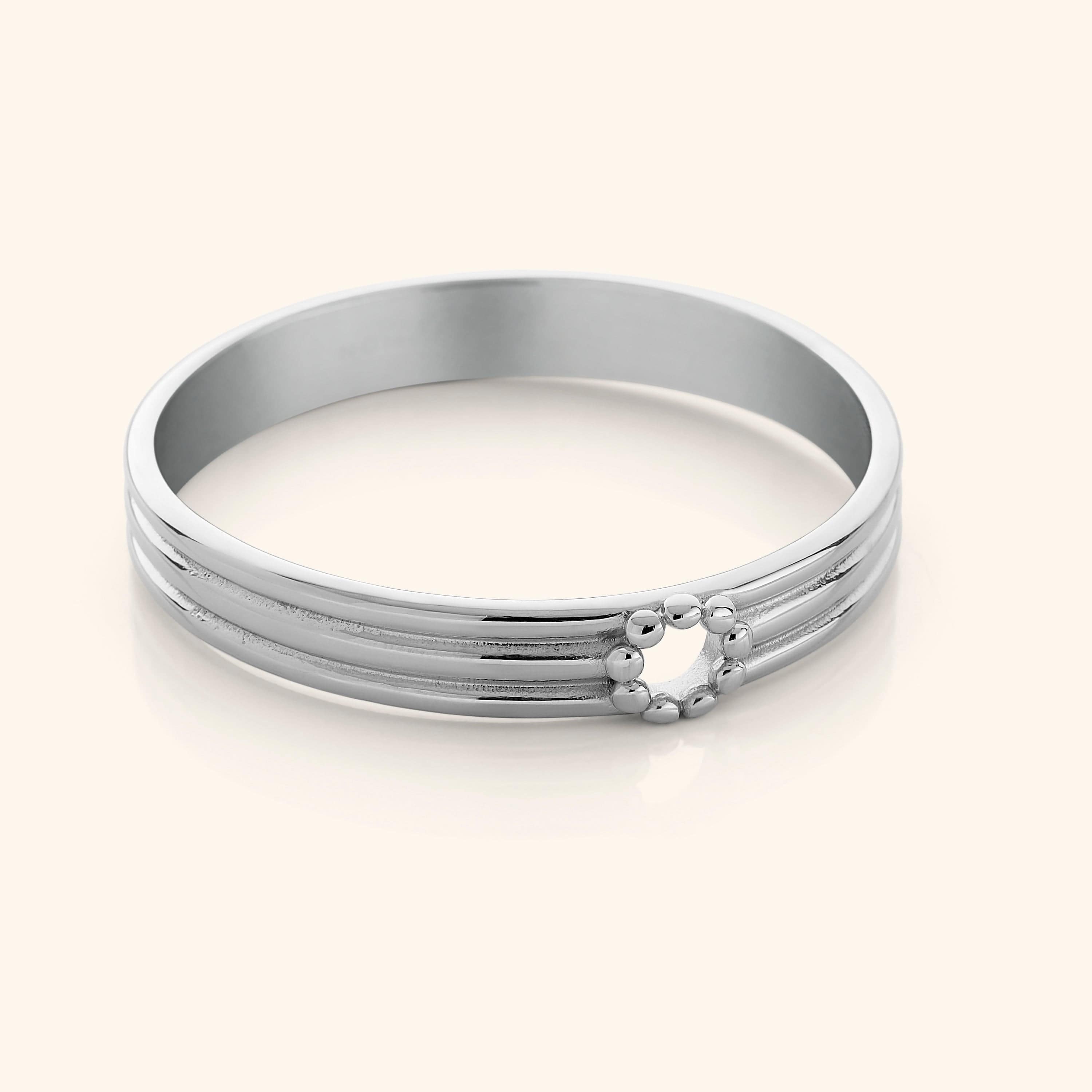 Elegant hand wearing the Eternal Blossom Bangle in a garden setting