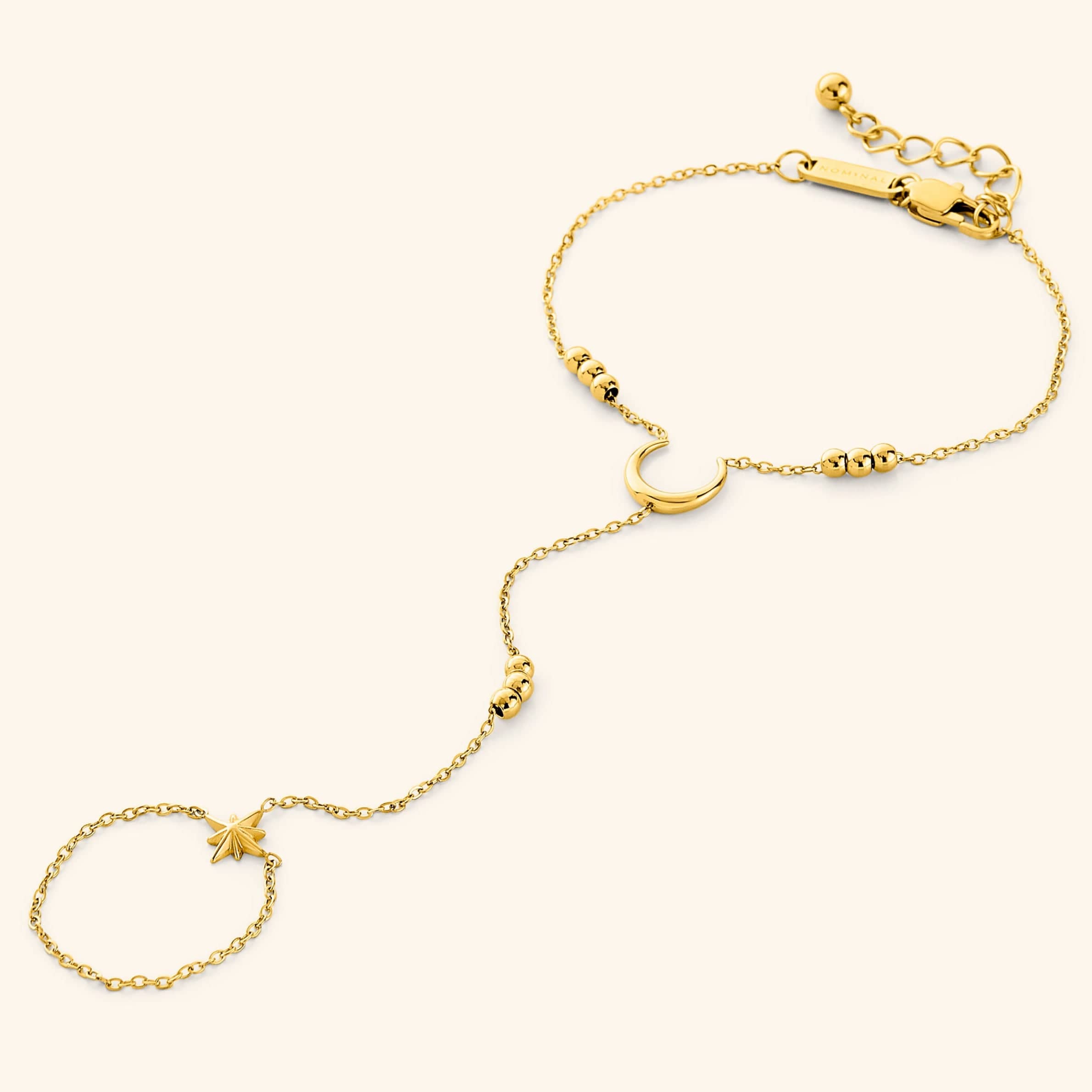Celestial gold hand chain displaying crescent moon and star details from a side angle.