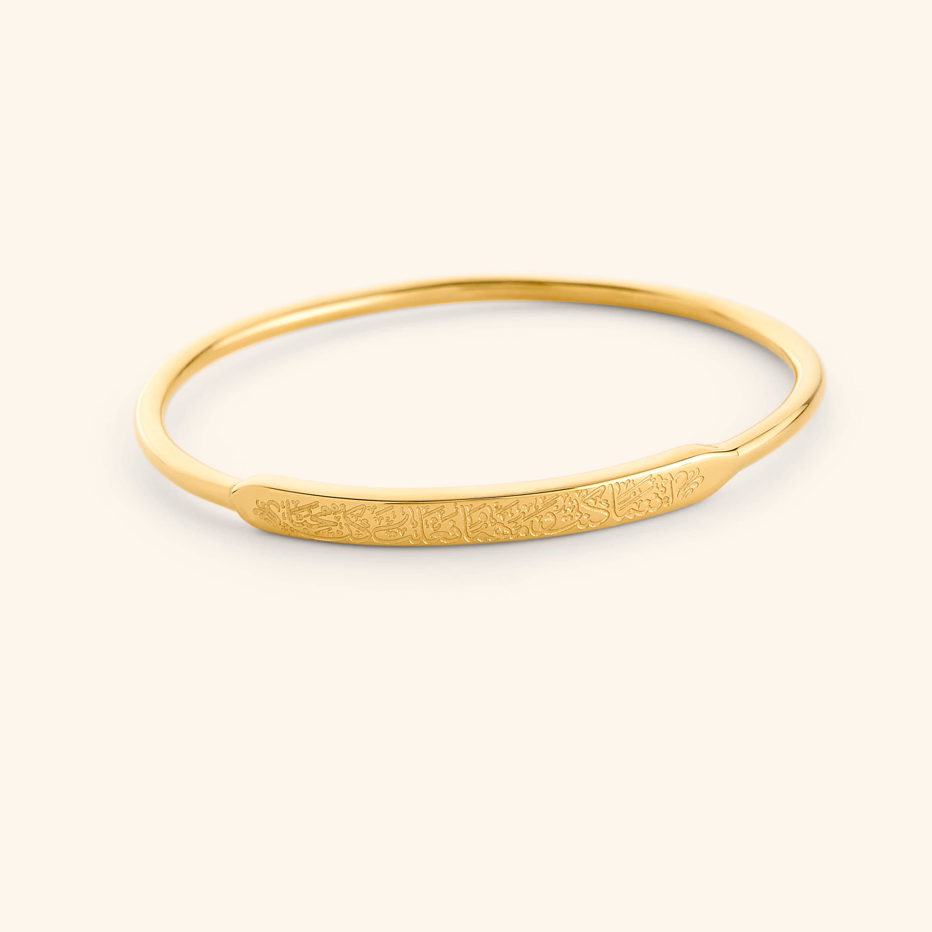 Close-up of gold bangle inscribed with Rumi quote — elegant inspirational jewelry