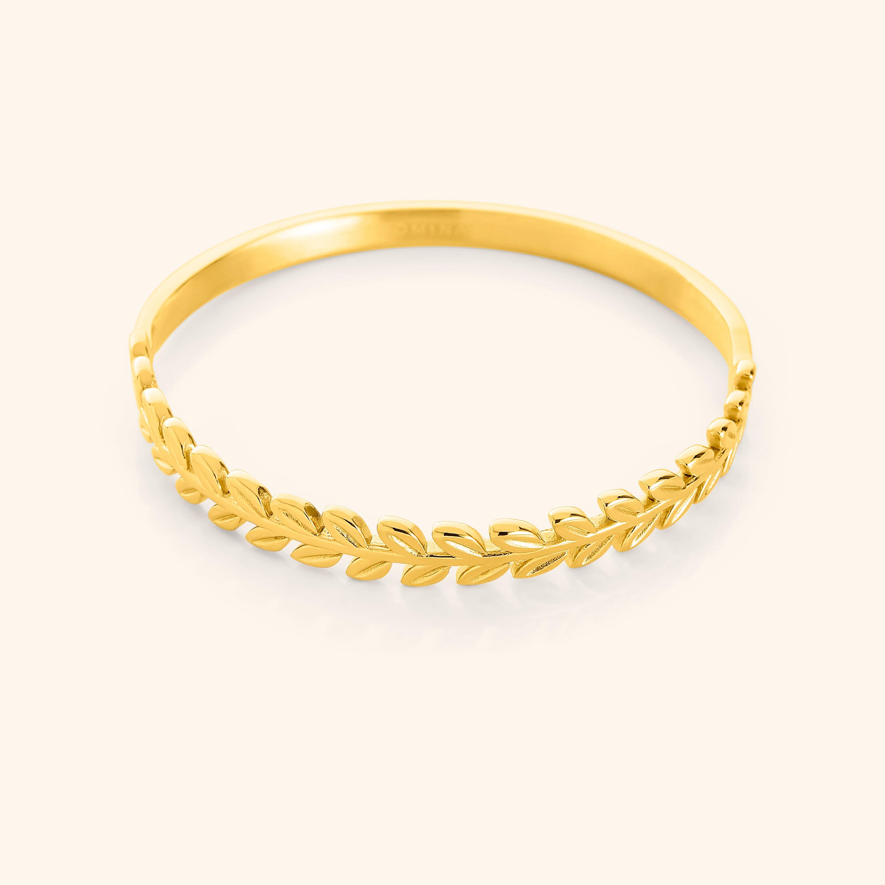 Elegant gold plated bangle featuring a twisted olive branch design from a side angle.