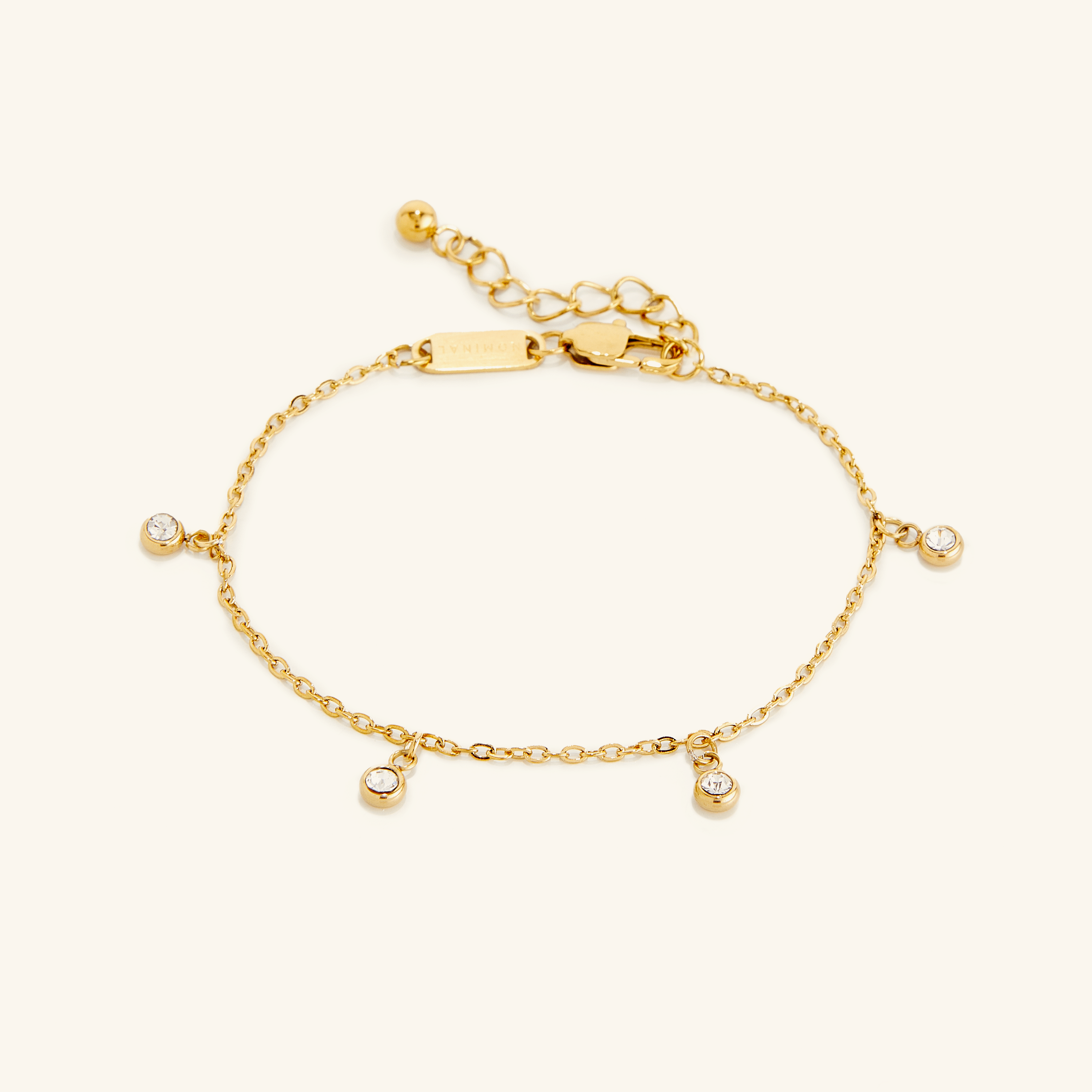 Close-up of gold bezel bracelet showing 18k plated links and sparkling gem details
