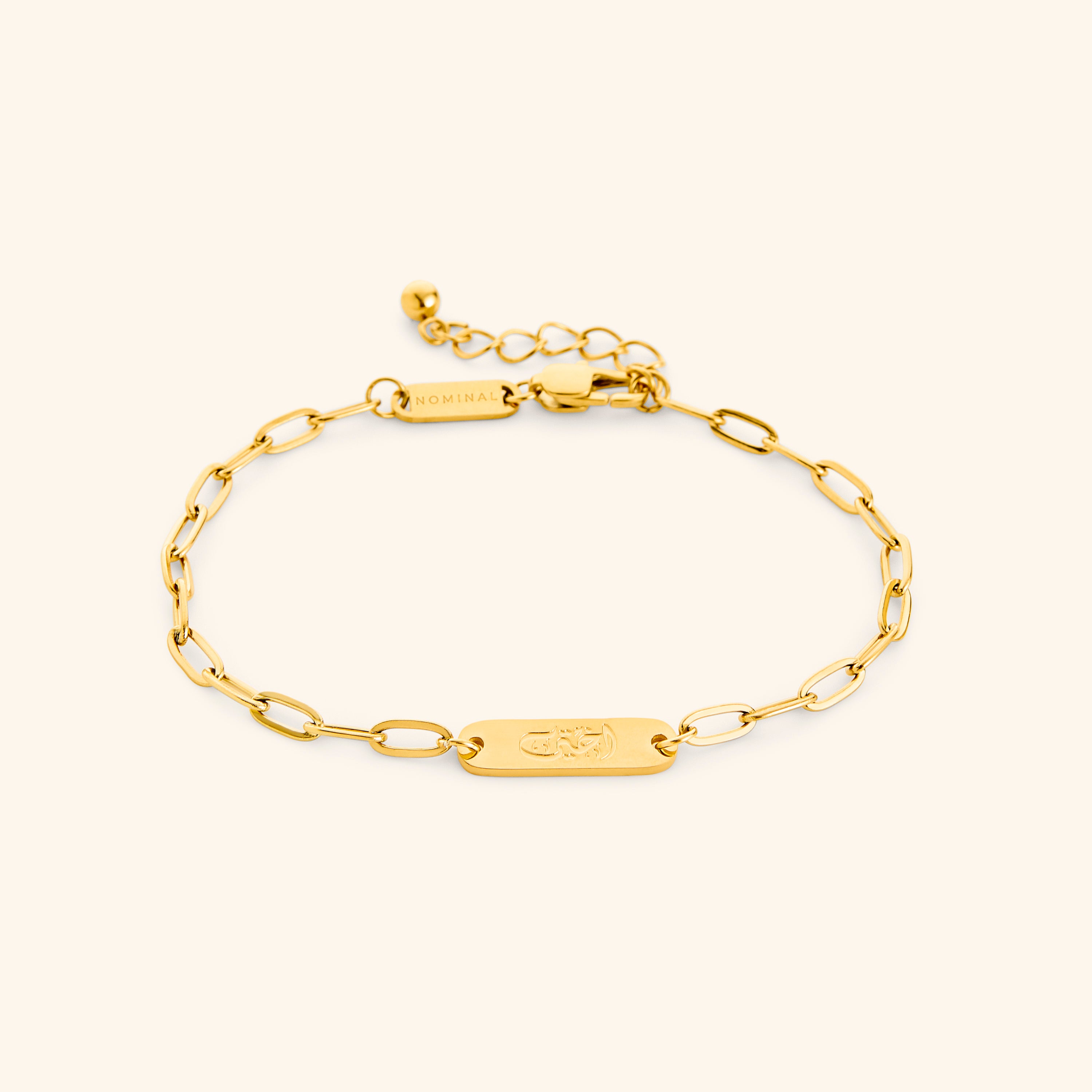 Close-up of the Ukhti link bracelet showcasing its Arabic inscription and gold finish.