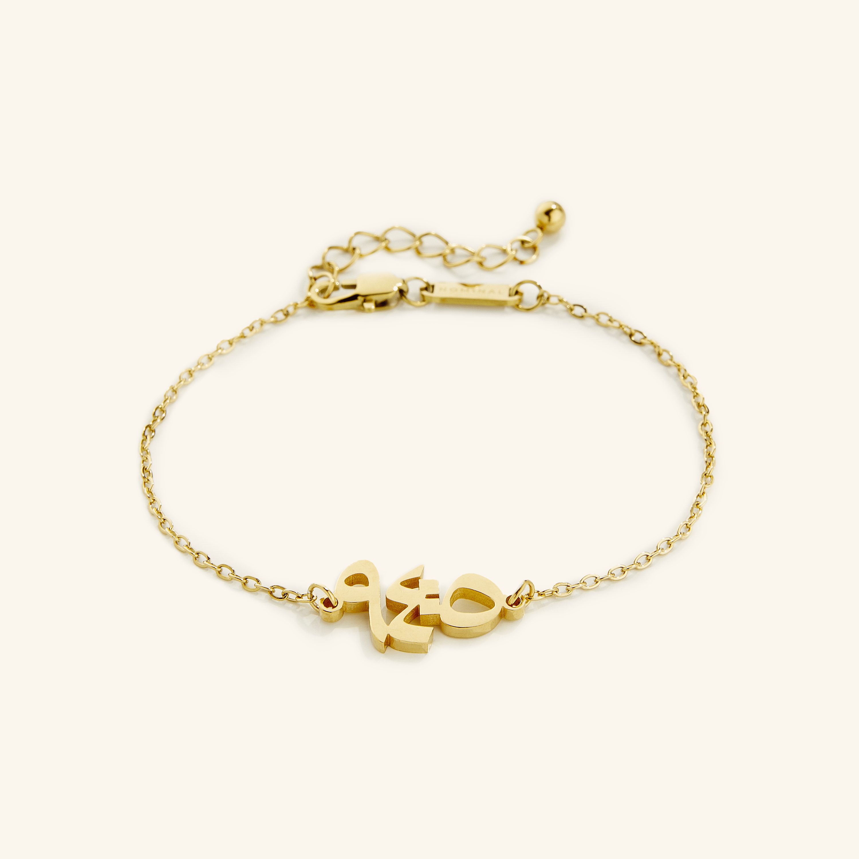 Close-up of the gold Quran verse bracelet showcasing Arabic calligraphy.