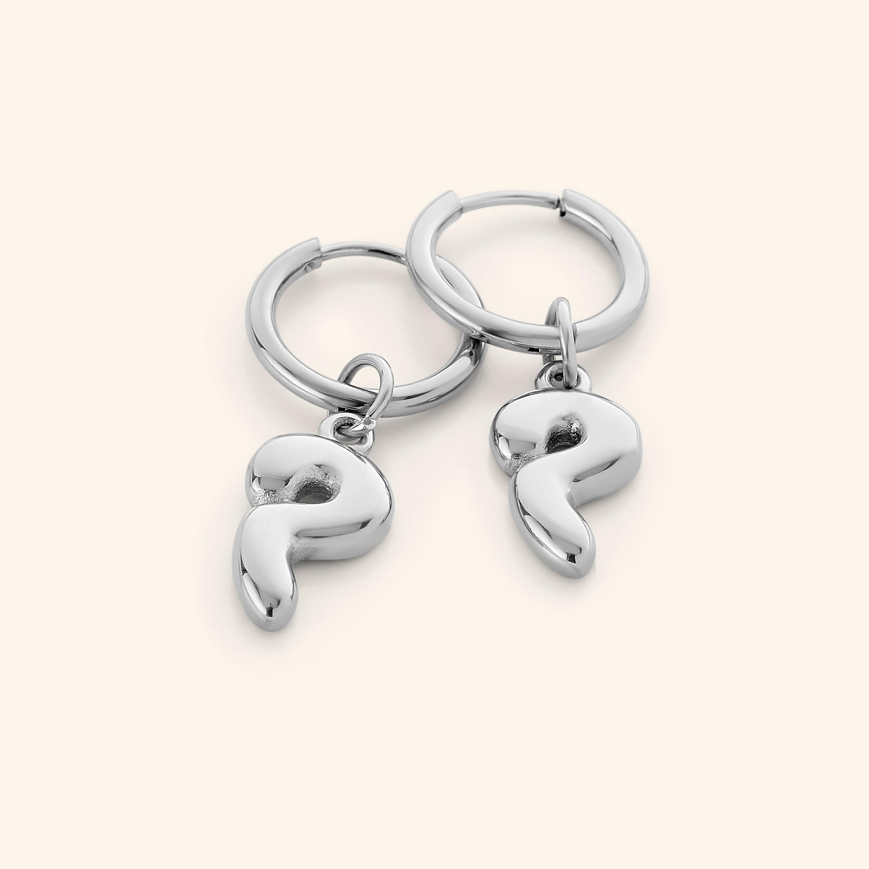 Side angle of personalized earrings worn on ear to highlight shine and size