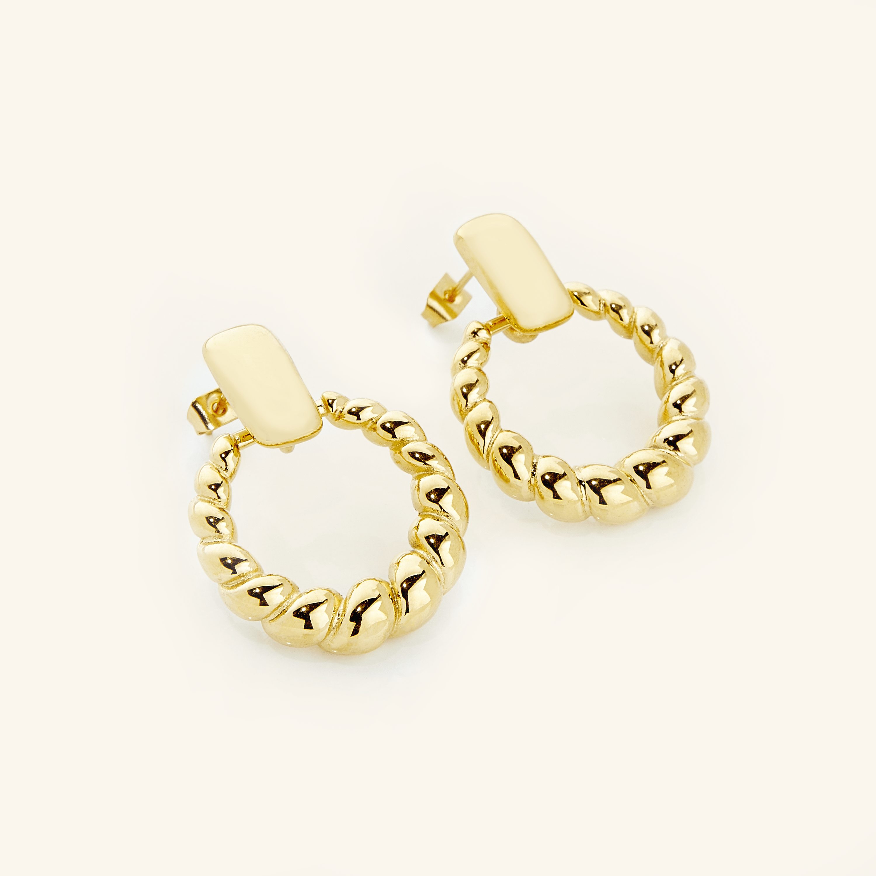 Chic braided statement hoops showcasing luxury design and waterproof feature.