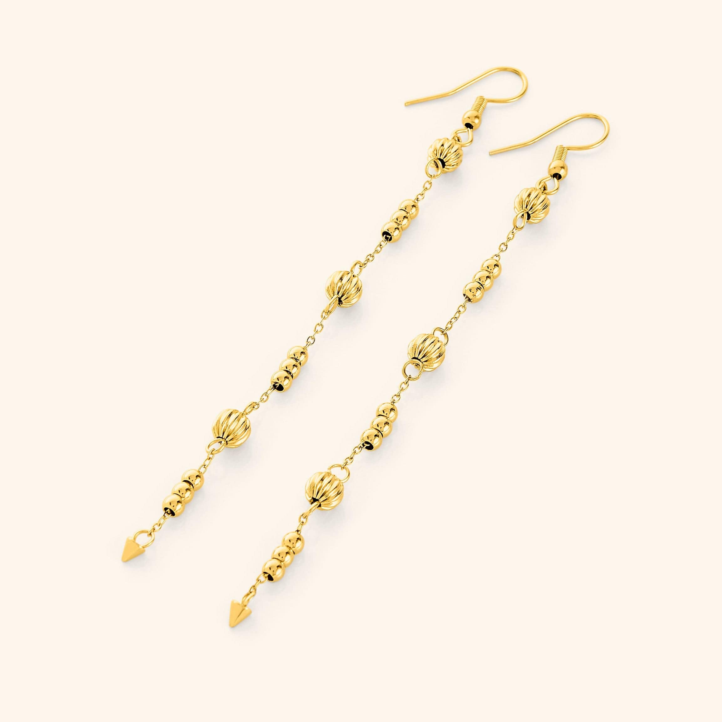 Celestial Glow Dangle Earrings displaying their vibrant shine against a velvet background.