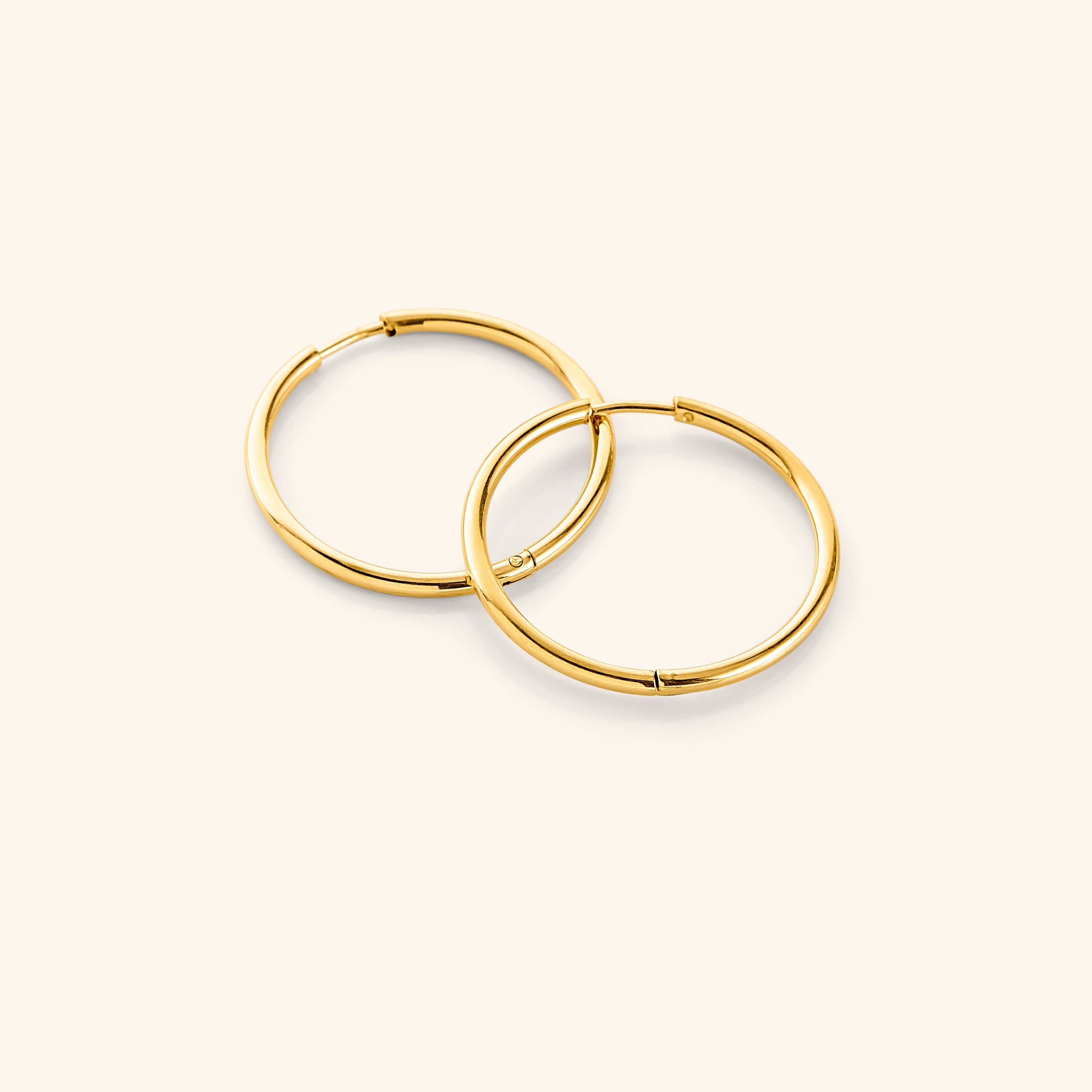 Close-up view of lightweight gold hoop earrings showing their shine and design.
