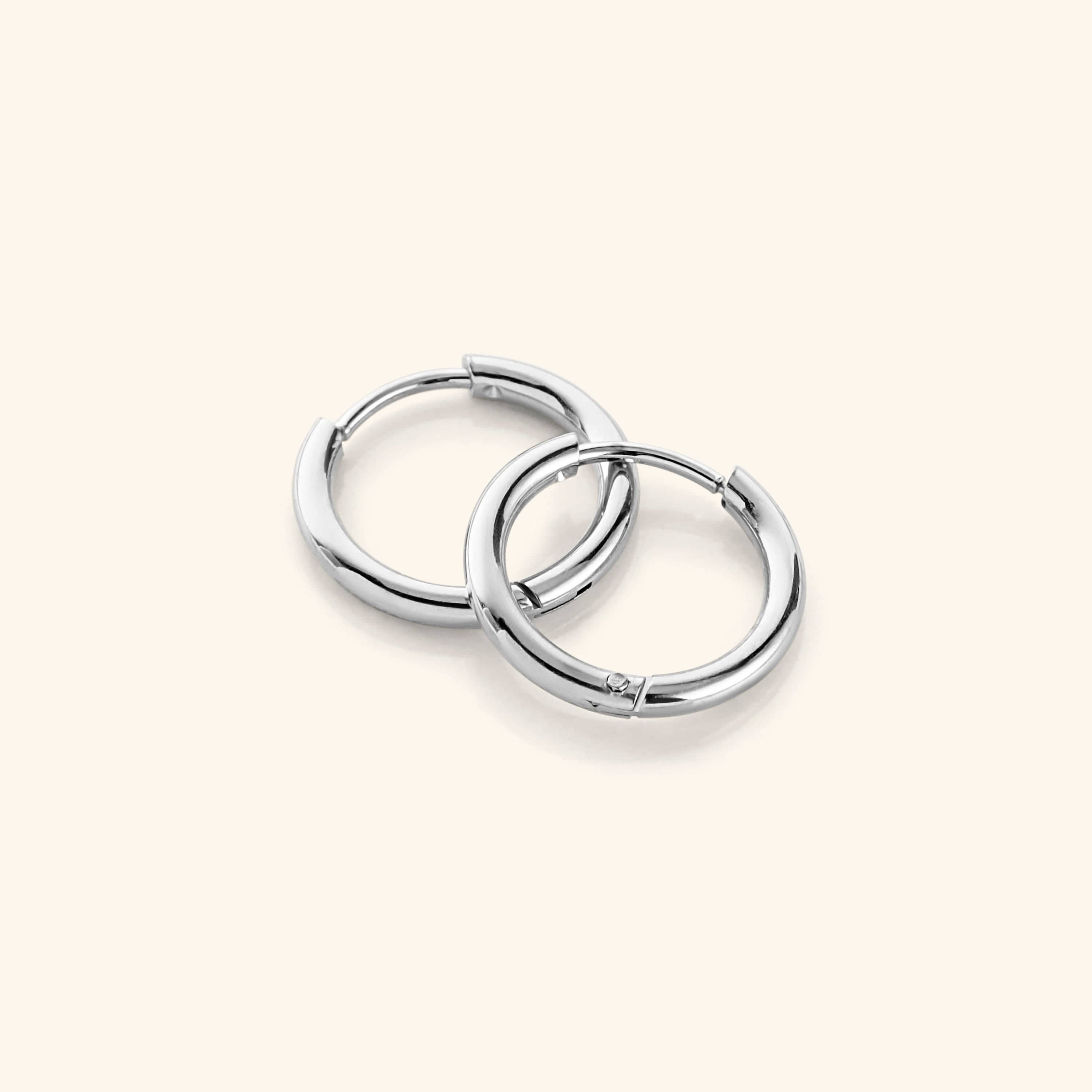 Close-up view of the small gold hoop earrings highlighting their 18K gold plating and shiny finish.