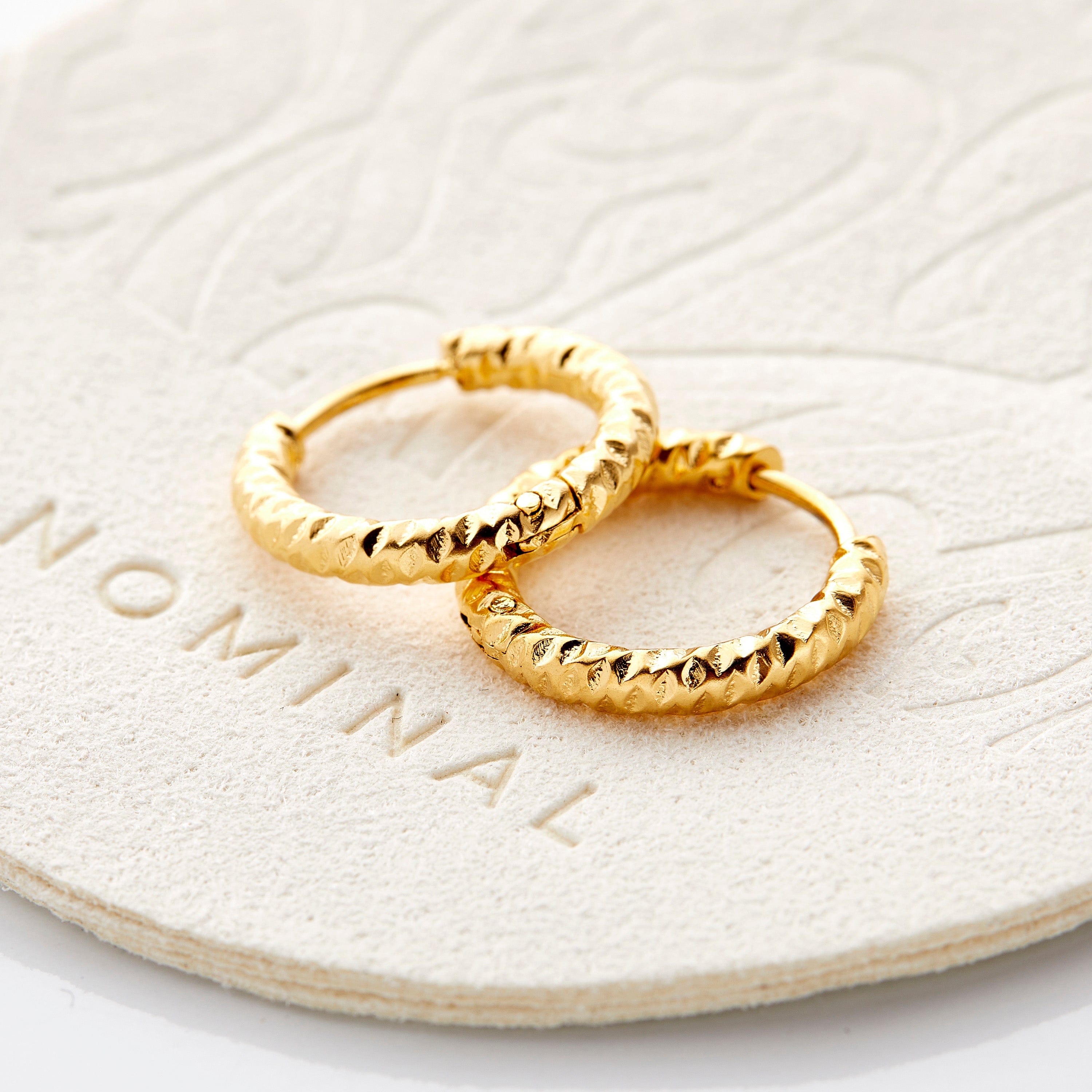 Mini gold hoop earrings for sensitive ears, showcasing the unique imperfect edges.