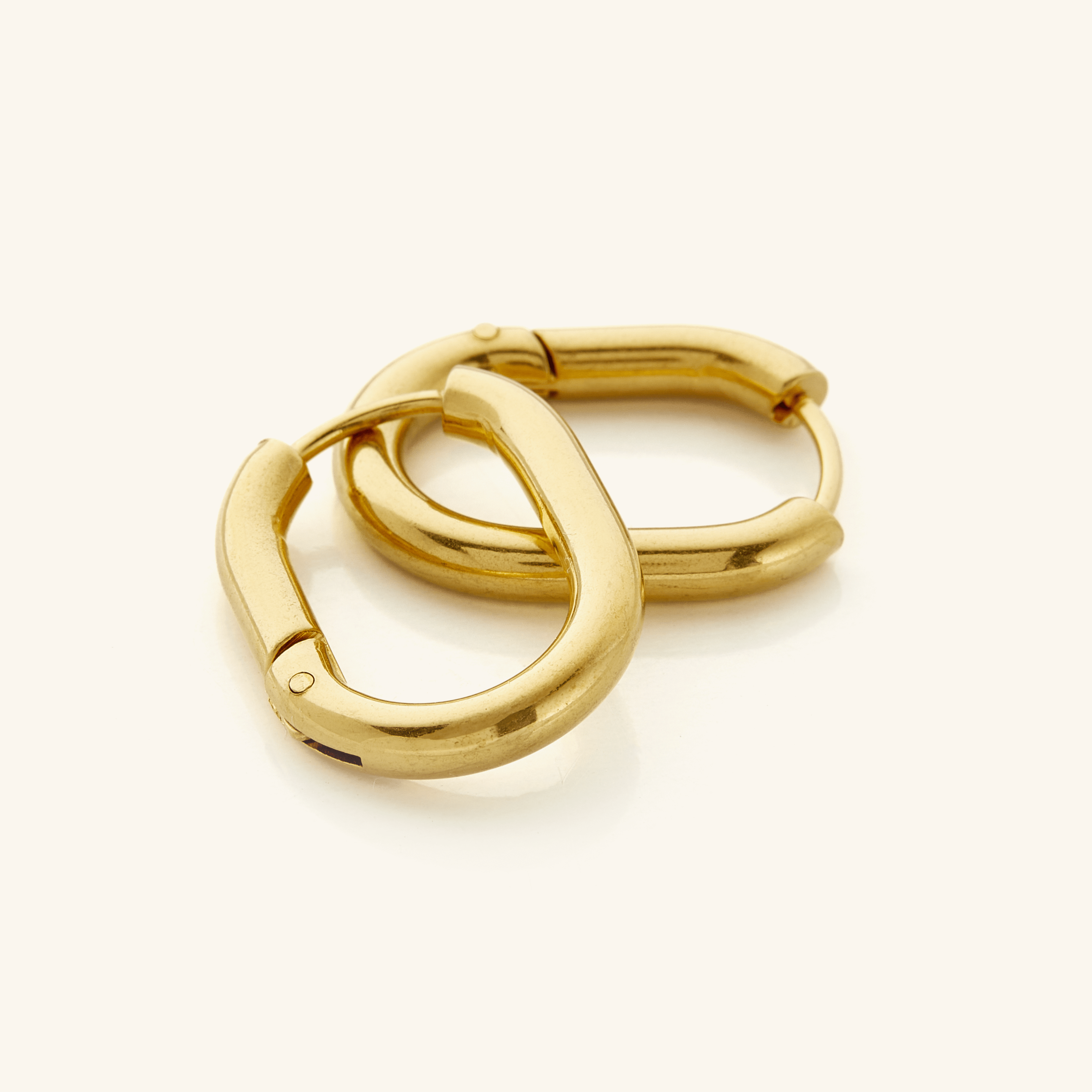 Close-up of Essential Gold Oval Hoop Earrings showcasing the shiny gold finish.