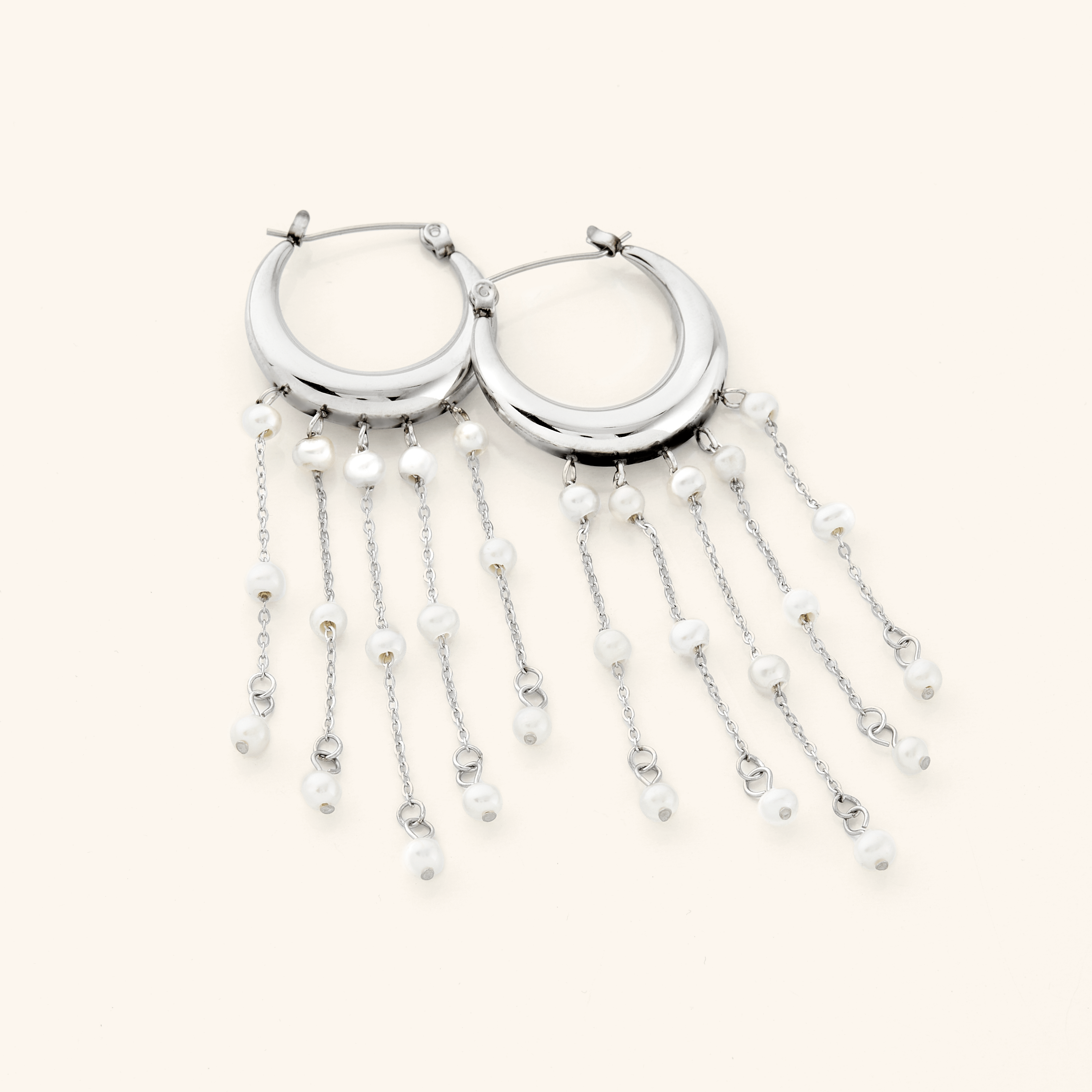Flat lay of celestial pearl hoop earrings on a soft fabric background, emphasizing their delicate design.