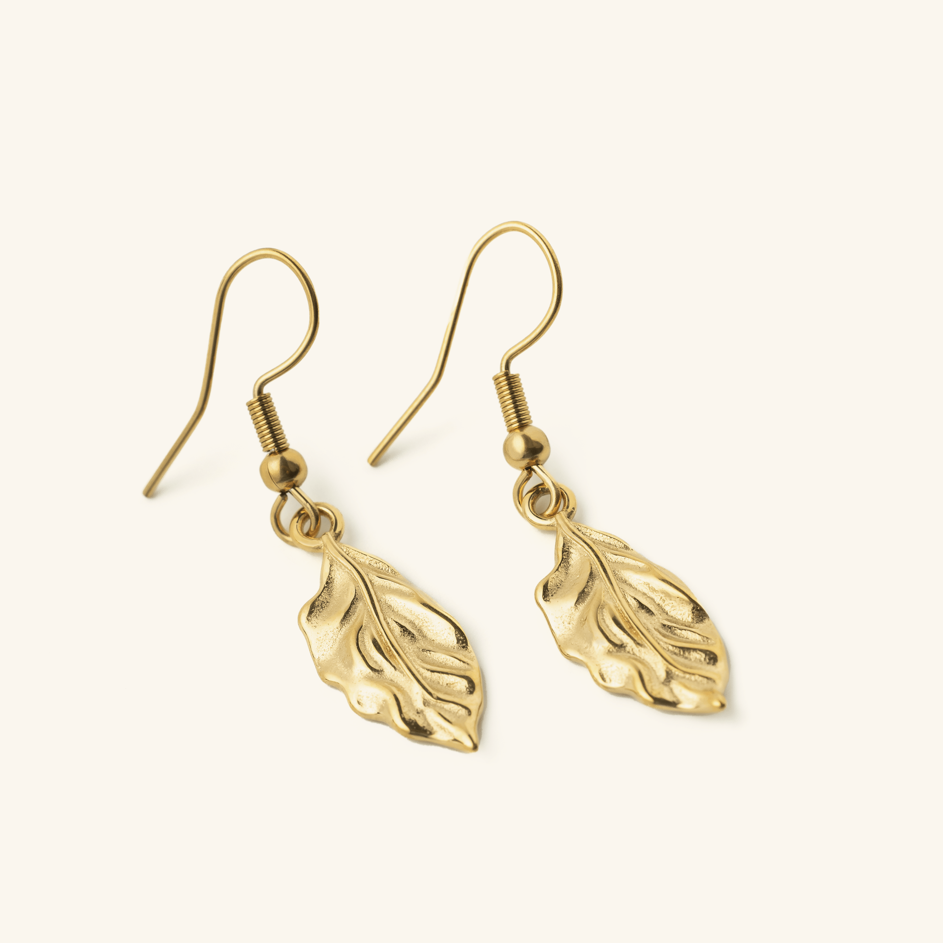 Close-up of vintage leaf earrings showcasing the intricate gold flaked design.