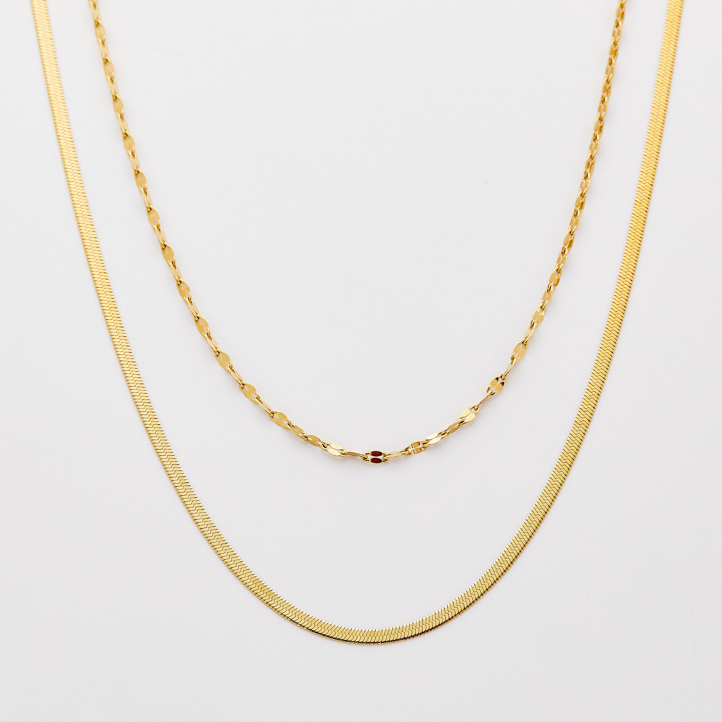 Elegant Herringbone and Flutter chains styled together at different lengths.