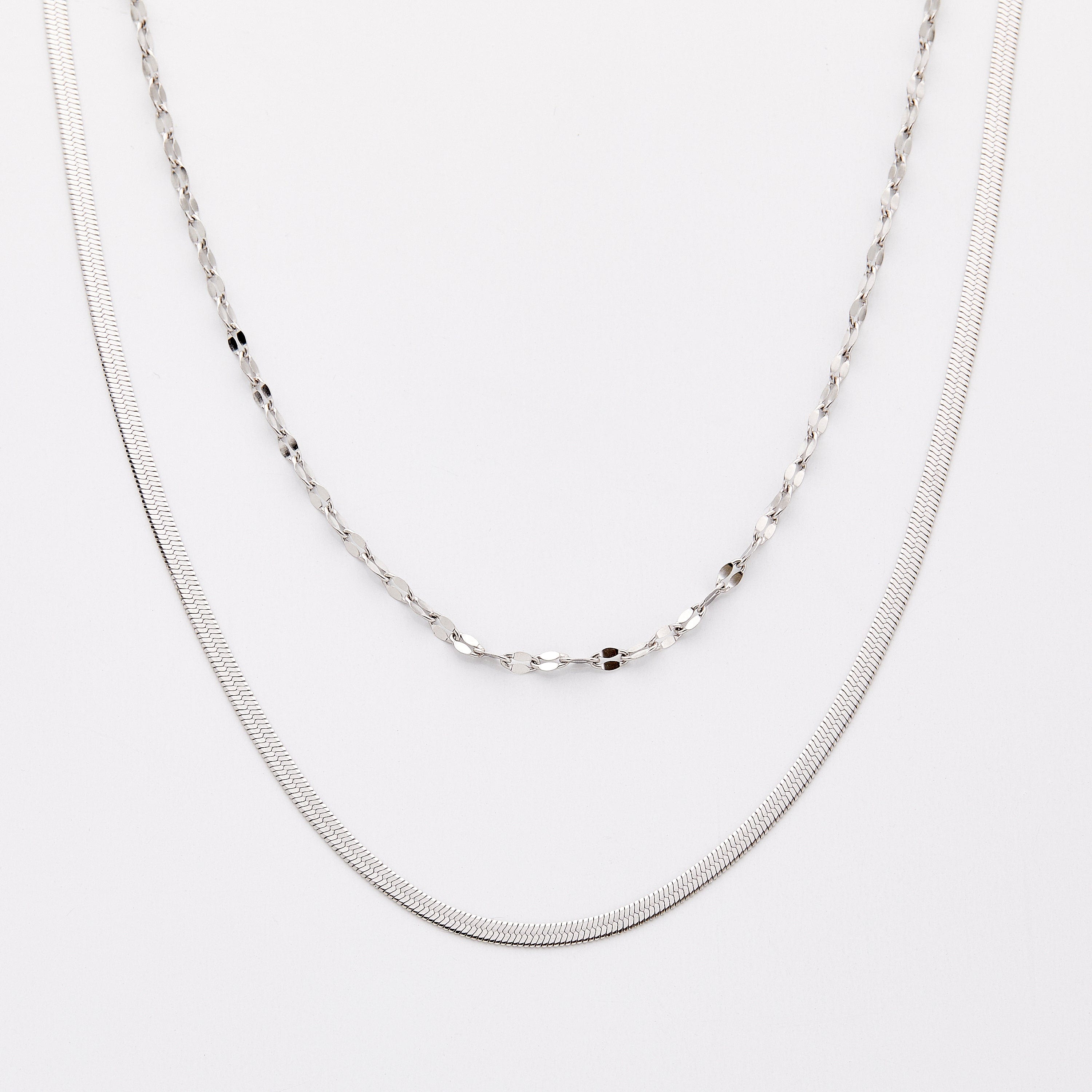 Elegant Herringbone and Flutter chains styled together at different lengths.