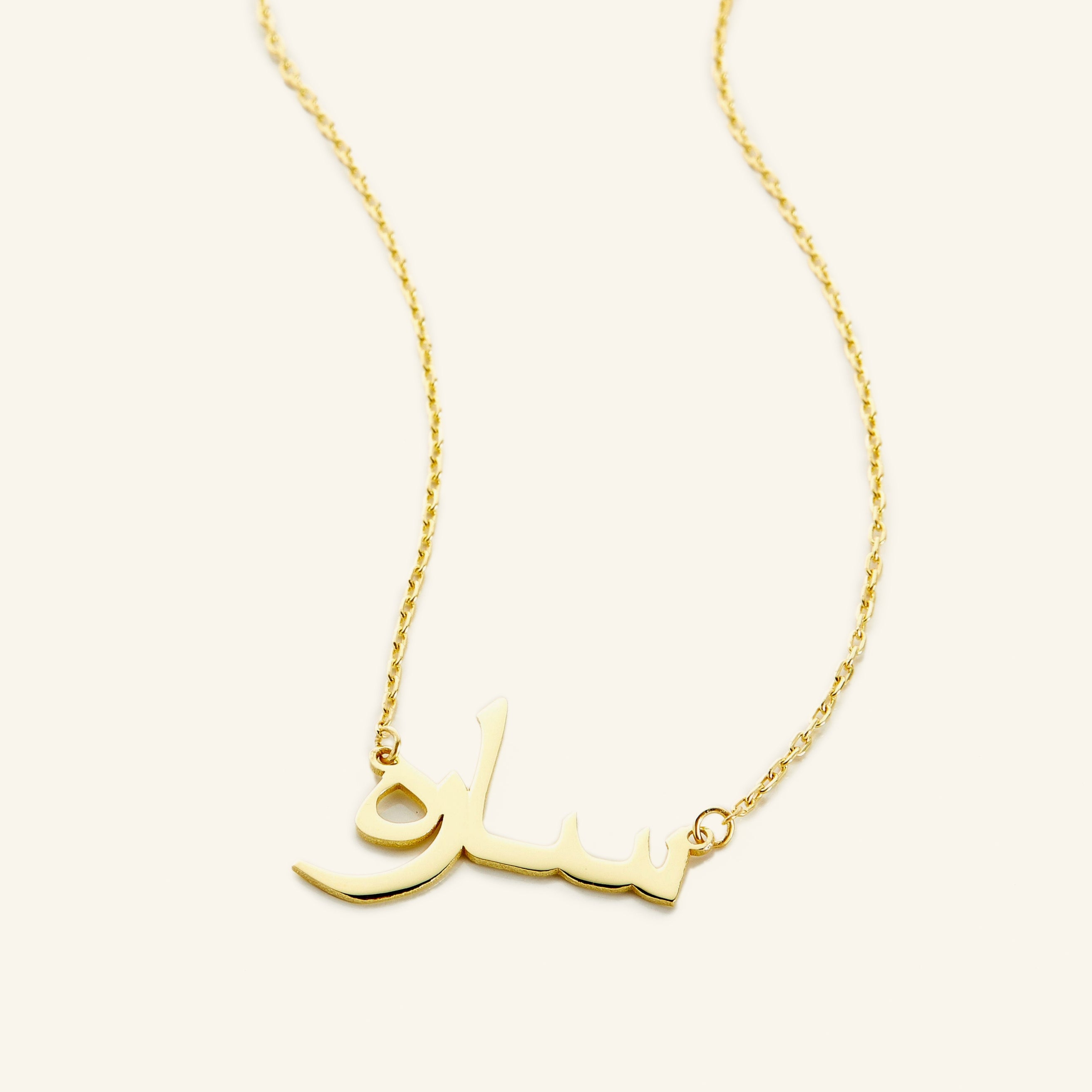 Front view of a personalized gold name necklace on a model, highlighting the custom design.