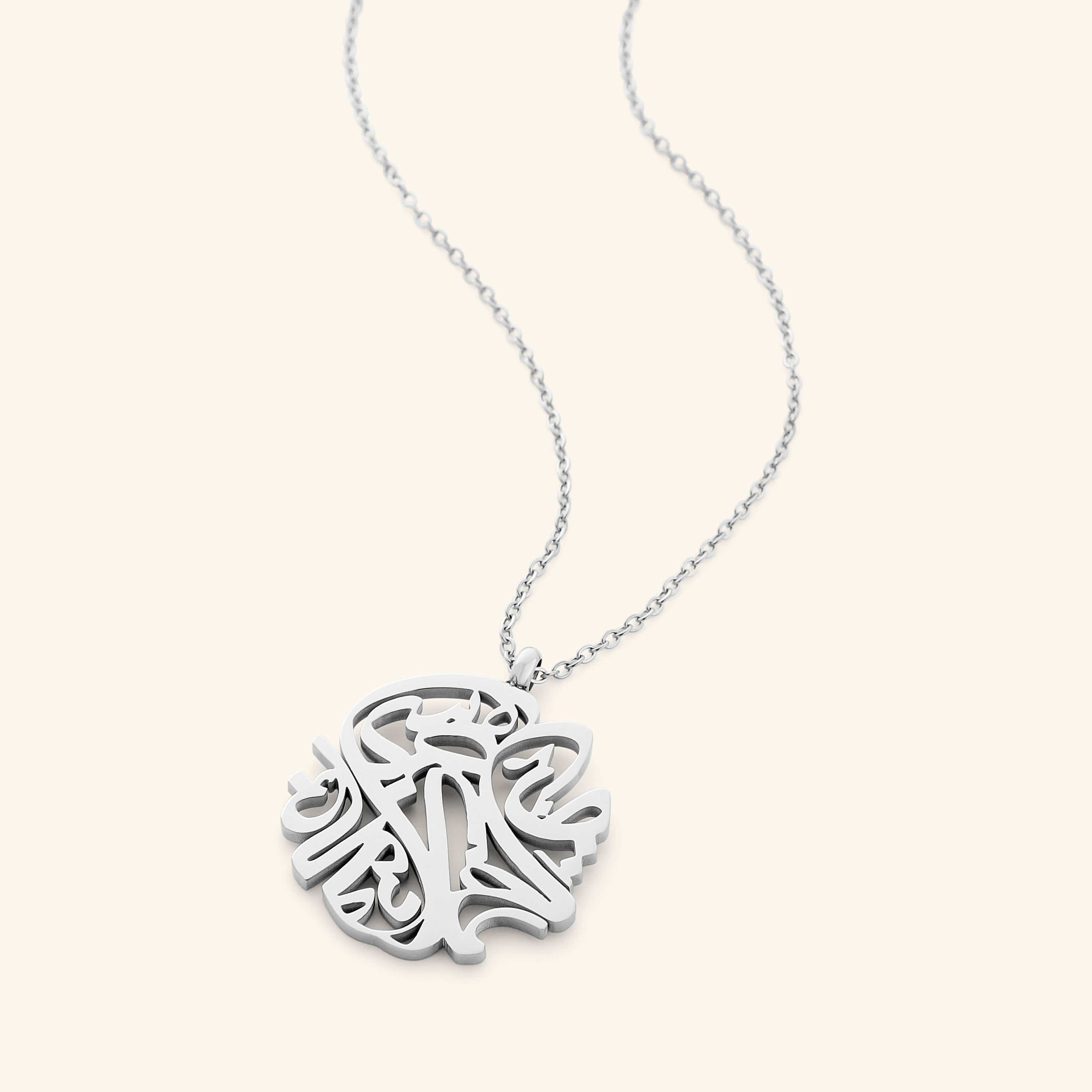Elysian Relief Necklace displayed elegantly on a velvet pouch, showcasing its intricate Arabic calligraphy.